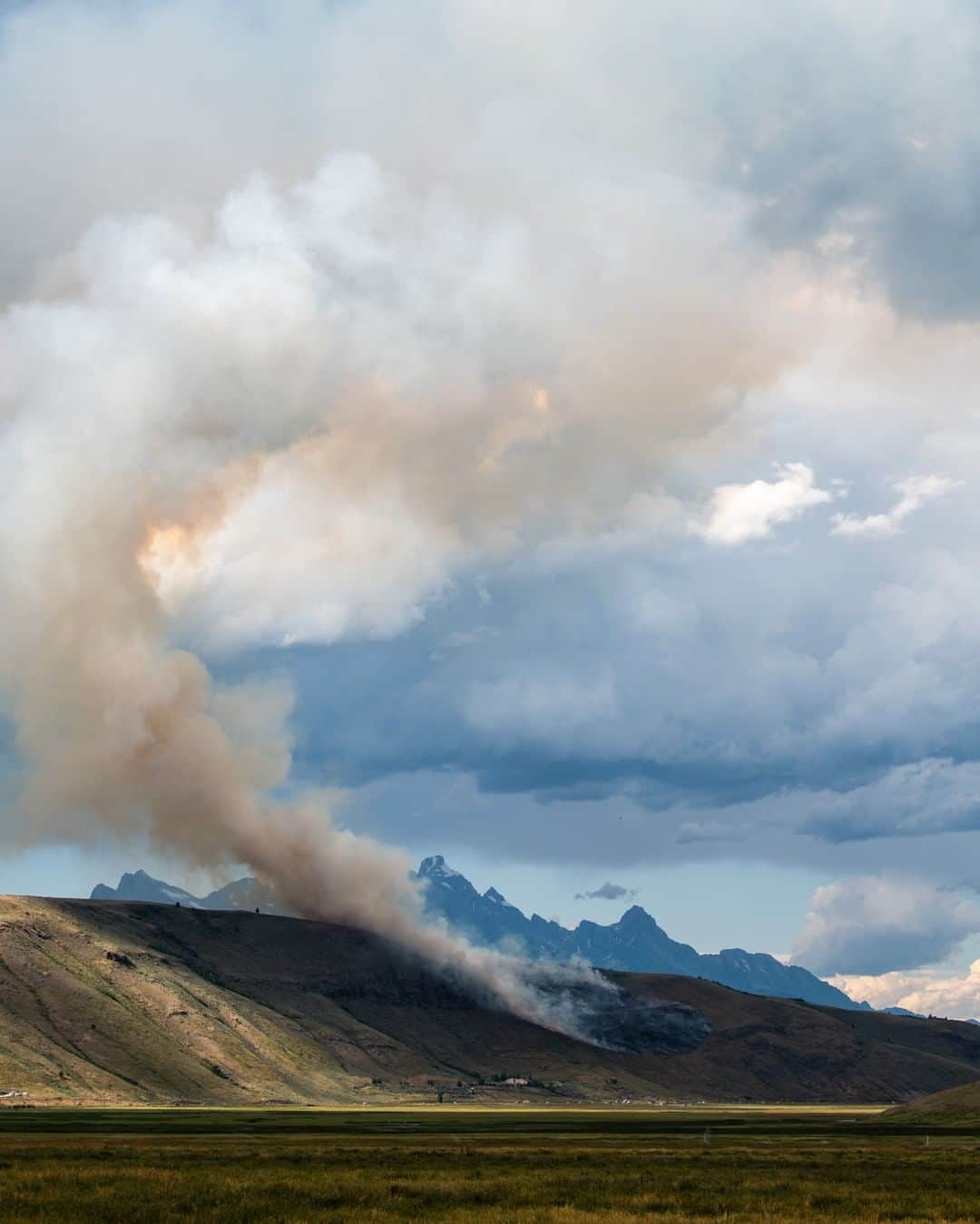 National Geographic Travelさんのインスタグラム写真 - (National Geographic TravelInstagram)「Photo by @taylorglenn | Smoke rises from a lightning-caused fire just north of Jackson, Wyoming. Fortunately, favorable weather conditions assisted the fire crews in controlling this event before any damage occurred aside from burning the hillside. In late summer, dry conditions make it very easy for fires to spark and with thunderstorms quite common in the afternoons these events happen frequently. Follow @taylorglenn for more from #Wyoming and beyond. #wildfire #tetons」8月16日 10時04分 - natgeotravel