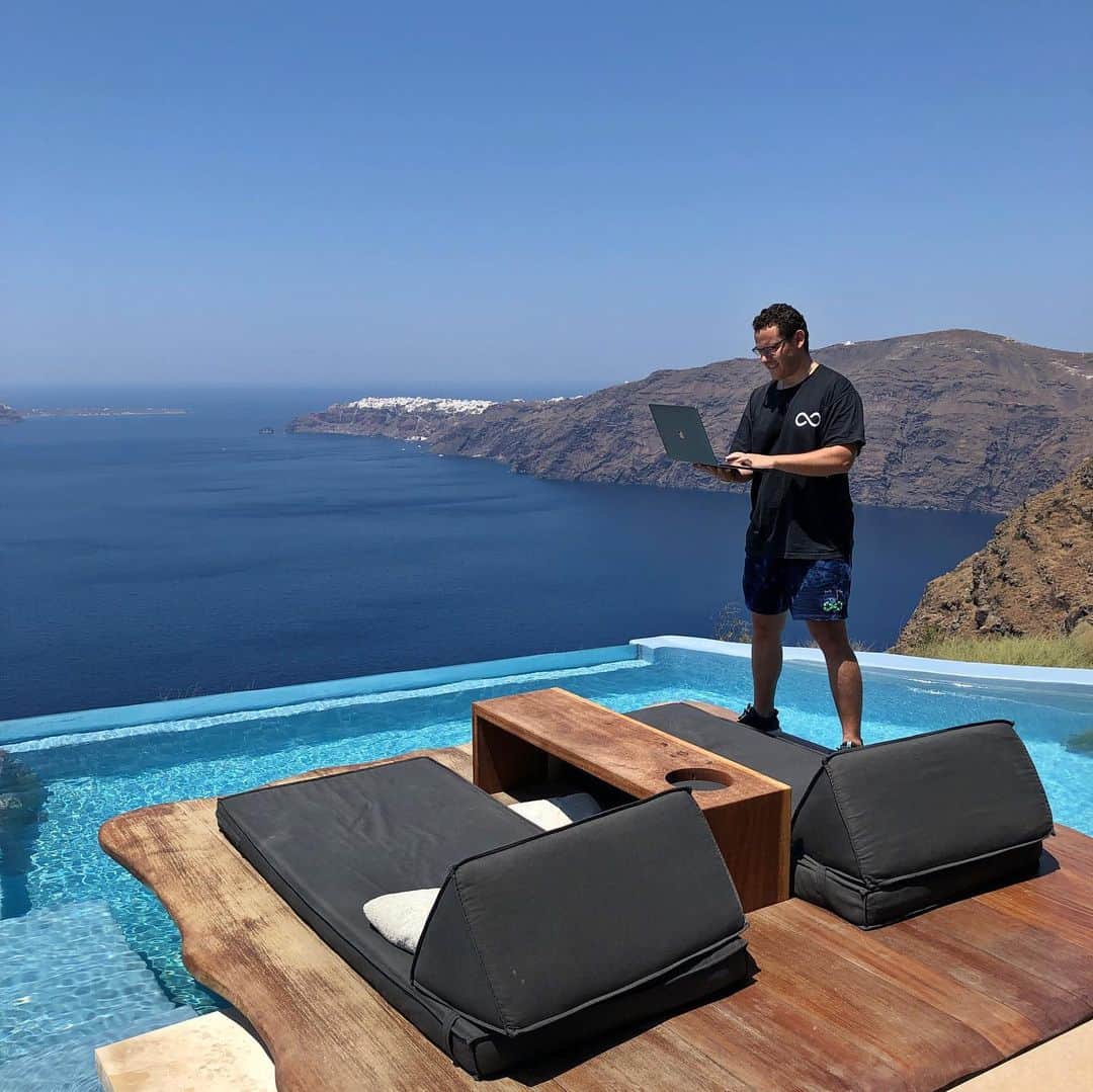 のインスタグラム：「Flashback to my badass #officewithaview in Greece at @cavotagoosantorini a few days ago and I’m proud to say the wifi is strong there, not to mention the views, hospitality and food are also incredible! Even though I love traveling EVERYWHERE I still have a #nodaysoff approach to my stock trading and teaching because I will NEVER take what got me here for granted. I’ll always just be a small-town guy from Orange, Connecticut who is blessed to live my dream life thanks to two decades of hard work and dedication to my craft, and always trying to get better. I know it doesn’t look like true freedom for me to be on my laptop or phone while I visit all these beautiful places, but I actually choose this madness as I’ve made more than enough money to live very comfortably without working another day in my life — that’s why I’m SO proud to now donate millions of dollars to charity through my @karmagawa foundation — and I just REALLY love my job! PS In the 2nd picture, I didn’t actually drop my laptop, I was testing my reflex skills just in case I dropped it…that’s how meticulous I am with practicing EVERY aspect of trading/teaching/traveling process! So, if you want to learn from me, how dedicated of a student will you be? Will you be obsessive down to the very last detail? Or will you be lazy like too many people in this world would dream of becoming a millionaire, but won’t put in the ridiculous time and effort required to actually make it happen? You tell me as I’m looking for truly dedicated students ONLY! #laptoplifestyle #workfromanywhere #jewswithviews #jewsatcavotagoo」