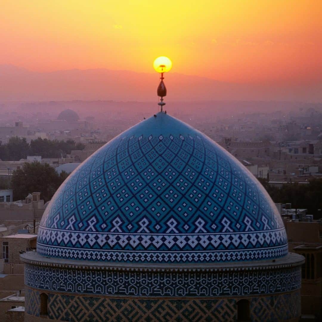 National Geographic Travelさんのインスタグラム写真 - (National Geographic TravelInstagram)「Photo by Michael Yamashita @yamashitaphoto | The sunset inflames the very top of the dome of the Jame Masjid in Yazd, Iran. Photographers luck: I stood on the roof of this mosque at sunset watching the sun as it dropped in the sky. To my surprise and delight, it fell with perfect placement over the top of the blue tiled dome. #Yzad #Iran #mosque」8月18日 6時57分 - natgeotravel