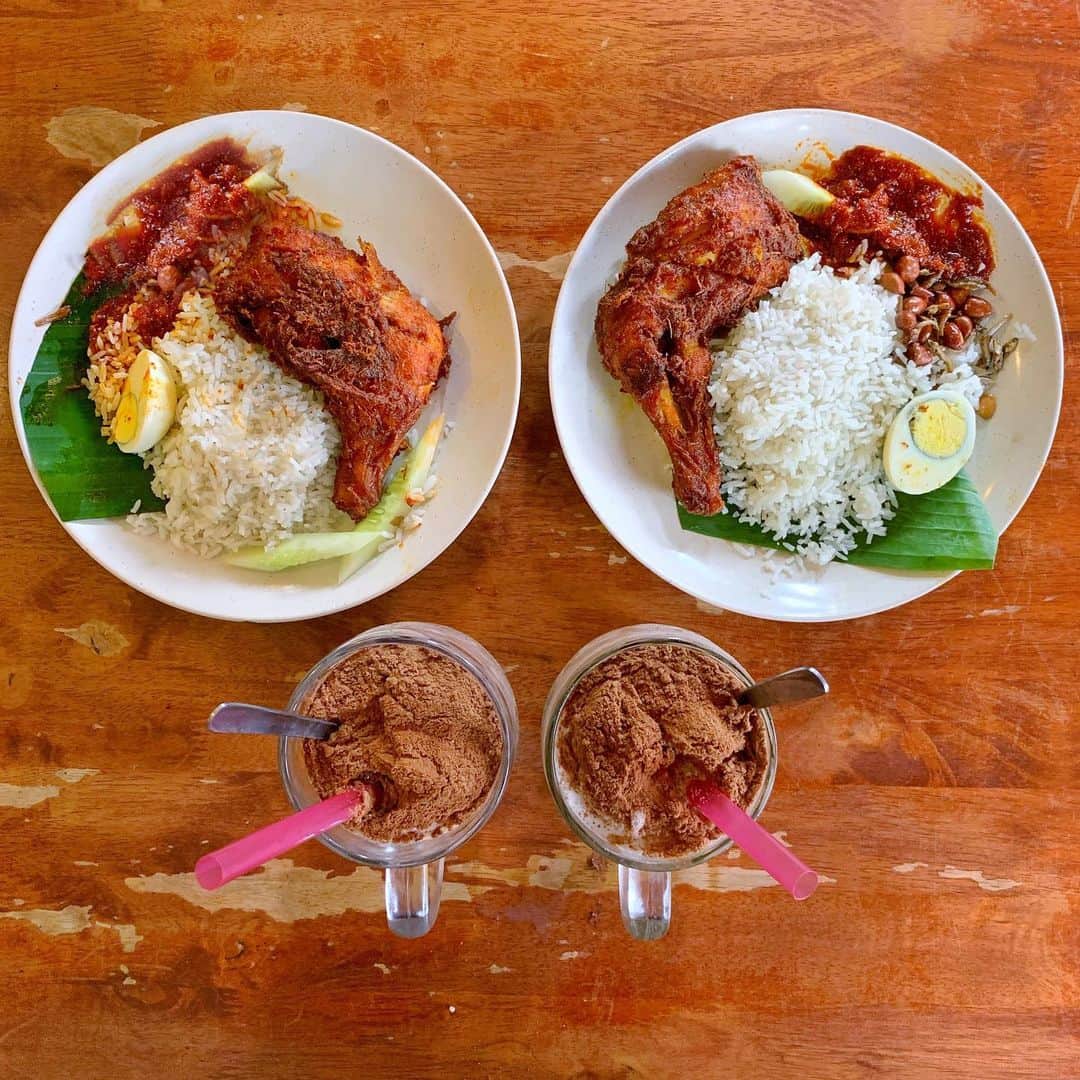 Symmetry Breakfastのインスタグラム：「Ciao Kuala Lumpur! 🇲🇾 It was a short but sweet (and spicy!) time in Malaysia. We have our suitcases at @villageparkofficial having Nasi Lemak Ayam Goreng before heading to the airport ✈️ Nasi Lemak means “fatty rice” as it’s cooked in coconut milk and is very fragrant. It’s comes with a spicy sambal sauce with ikan bilis, a small dried fish and ours with a side of ayam goreng, fried chicken!  Add a frozen Milo slushie to that and you’ve got a perfect goodbye! Nasi Lemak is mostly eaten for breakfast but places like Village Park serve it all day. It’s so iconic I even had a recipe in my first book! Thanks again Malaysia and Singapore last week! See you sooooon 😘😘😘 #symmetrybreakfast #nasilemak #villageparknasilemak #malaysianfood - - - - - - - - - - - - - - - - - - - - - - - - - - - - - - - - Images 1, 2 and 3 Village Park Restaurant and their famous Nasi Lemak - Image 4 Sri Nirwana Banana Leaf Curry Restaurant (dinner last night!) Image 5, 6 and 7 at @therumahotel where we stayed Image 8 SNACKS with strange babies」