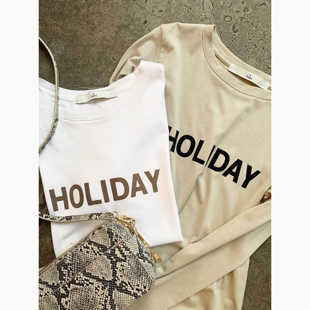 TIARAさんのインスタグラム写真 - (TIARAInstagram)「"HOLIDAY" Tシャツ 今年トレンドのTシャツ。 今の時期にはとにかく頼れる存在！ TIARAで大人気の"HOLIDAY"ロゴをあしらった TシャツとロングTシャツを展開中です。 ・ すっきりとしたサイズ感でカジュアルになり過ぎず 大人の方におすすめのTシャツです。 今の時期はギャザーのロングスカートなどで涼しげに 秋口はチュールのスカートを合わせたり、 ジャケットやカーディガンのインにもぴったり！ 女性らしいアイテムと合わせた 甘辛なコーディネートがおすすめ。 パイソン柄バッグでトレンド感をプラス。 ・ ホワイトにはグレージュロゴ、 グレージュにはブラックロゴの2色展開。 フロッキープリントのロゴが可愛い！ 是非一度お試しいただきたいTシャツです。 ・ ¥6.400+tax(short) ¥9.400+tax(long) color / ホワイト、グレージュ bag ¥8.800+tax(La piece) ・ ・ #tiara #tiaramelrose #ティアラ #ロゴtシャツ #holidaytシャツ #大人tシャツ #パイソンバッグ #大人ロゴtシャツ #大人カジュアル #きれいめファッション #きれいめカジュアル #大人カジュアルスタイル #ママファッション」8月19日 19時06分 - tiara_melrose