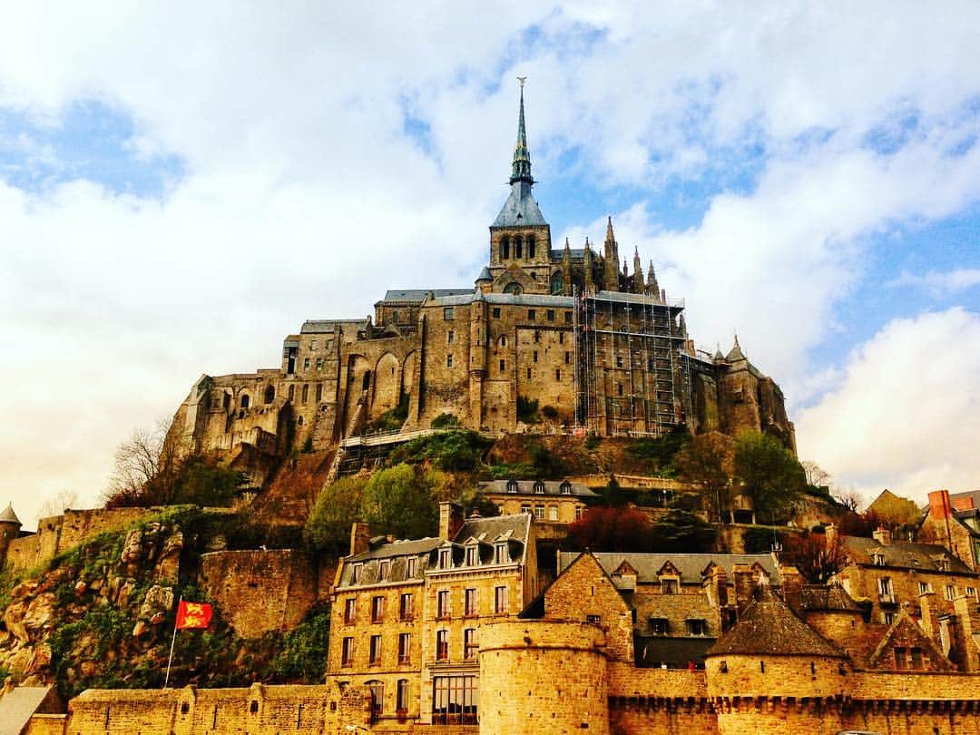 旅行比較サイト・トラベルコ 理想の旅を、いちばん安く。のインスタグラム：「断崖に堂々とそびえ立つ美しい修道院…✨ * こちらはフランスが誇る世界遺産、 #モンサンミッシェル 。大天使ミカエルのお告げにより岩山に聖堂が建てられてたことがはじまりとされ、聖地として発展、後に修道院が建てられました。戦乱と革命の中で、要塞や監獄として使用されたことでも有名です。 * 写真📸のように外側から見るモン・サン・ミッシェルはもちろん、増改築が繰り返され、さまざまな建築様式が混ざり合った修道院も見どころ満載◎ * フランスに行ったら、ぜひ訪れてほしいスポットのひとつです！ * * * あなたが訪れた旅先での写真に《 @travelko_chan 》《 #トラベルコ 》《 #travelko 》とタグ付けして投稿してみてください！こちらのアカウントで紹介させていただくかもしれません♪ * * * #フランス #France #モンサンミッシェル #montsaintmichel #normandie #世界遺産 #worldheritage #絶景 #海外旅行 #travel #trip #landscape #view #sightseeing #フォトジェニック #旅行好きな人と繋がりたい #写真好きな人と繋がりたい #女子旅 #一人旅 #カメラ女子 #カメラ男子 #photooftheday #followme #instatravel #travelgram #instagood #instaphoto #travelko #トラベルコ #トラベルコちゃん @francefr @montsaintmichel_normandie」