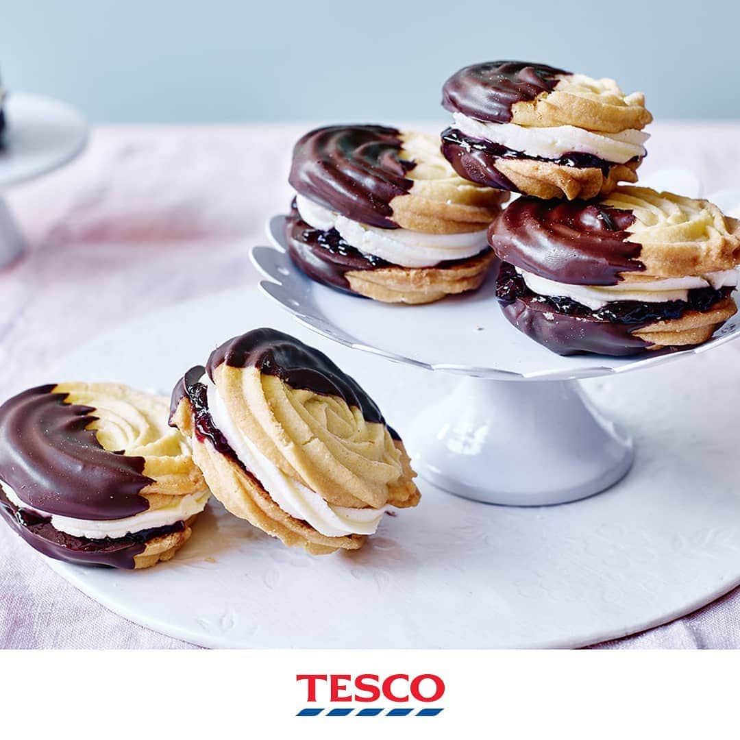 Tesco Food Officialさんのインスタグラム写真 - (Tesco Food OfficialInstagram)「Were you watching last night’s #GBBO Biscuit challenge like 😍😍😍? #BakeOff some chocolate-dipped showstoppers of your own with these irresistible black forest Viennese Swirls.  Ingredients 250g unsalted butter, softened 50g icing sugar, sifted 250g plain flour, sifted 60g cornflour, sifted 1/2 tsp vanilla extract 200g (7oz) dark chocolate, broken into pieces For the filling 100g unsalted butter, softened 200g icing sugar, sifted ½ tsp vanilla extract 100g Morello cherry conserve  Method Heat the oven to gas 5, 190°C, fan 170°C. Line and grease 2 baking trays with nonstick baking paper. In a food processor, blend the butter, icing sugar, plain flour, cornflour and vanilla extract until smooth. Spoon into a piping bag fitted with a large open star nozzle and pipe 24 rosettes, 4cm wide, leaving space for spreading. Transfer to the oven to bake for 10-12 minutes, or until lightly golden and firm to the touch. Leave to cool on the trays for 5 minutes before transferring to a cooling rack to cool completely. Put the broken chocolate in a heatproof bowl over a pan of barely simmering water. Melt slowly for 3-4 minutes, then stir gently until smooth. Cool slightly, then dip each biscuit halfway into the chocolate, coating the front and back. Return to the trays, thenA put in the fridge for 10 minutes. Meanwhile, make the filling. Beat the butter, icing sugar and vanilla until light and fluffy. Spoon into a piping bag fitted with a large open star nozzle. Spread 1/2 tsp conserve over half the biscuits then pipe with a thin, even layer of buttercream. Sandwich together with another biscuit, continuing until you have 12 whirls.」9月4日 19時03分 - tescofood