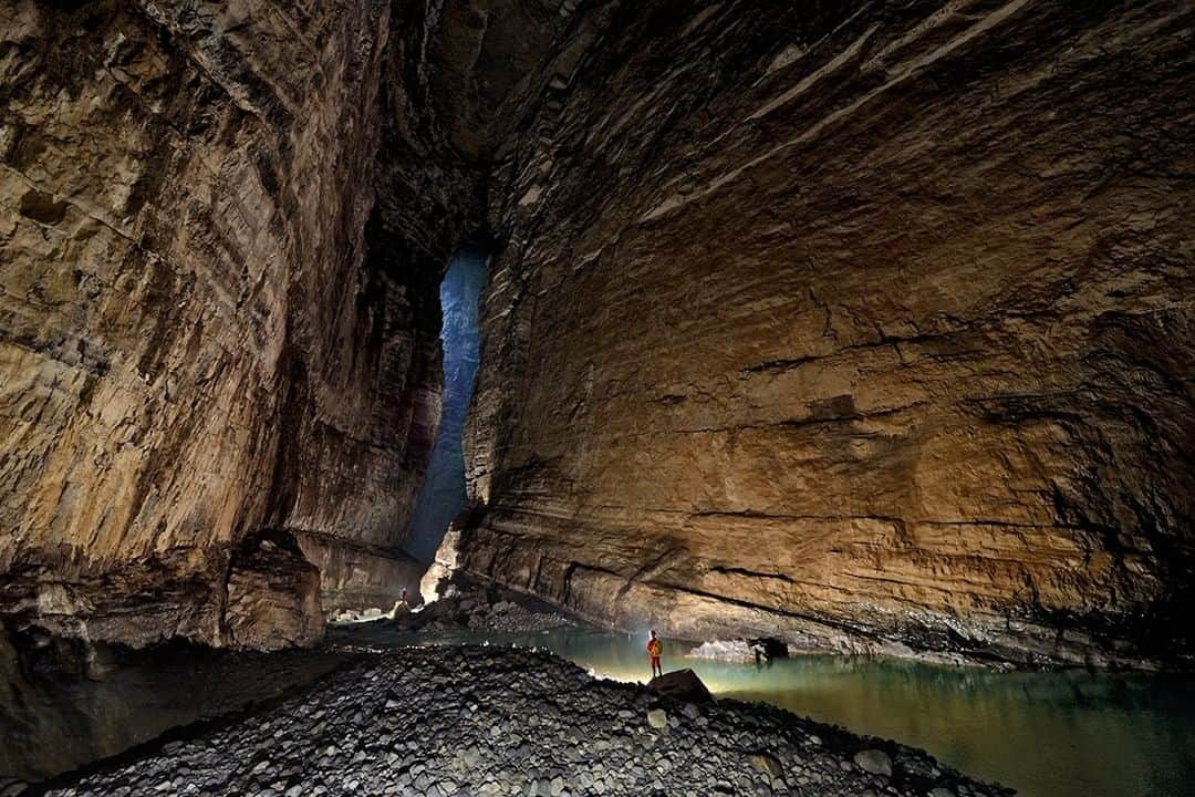 ナショナルジオグラフィックさんのインスタグラム写真 - (ナショナルジオグラフィックInstagram)「Photo by Robbie Shone @shonephoto | China boasts some of the world's most spectacular underground landscapes. Several of the largest cave chambers ever discovered are located in China, and probably many more are there, lying in total darkness just waiting to be found. This photo of the entrance passage of Quankou Dong, near the town of Tongzi, leads through to one of those mighty chambers, Cloud Ladder Hall. This shows the view back toward the towering entrance and the main river passage, where we see thick beds of limestone that are visible high in the roof of the cave.」8月21日 11時34分 - natgeo