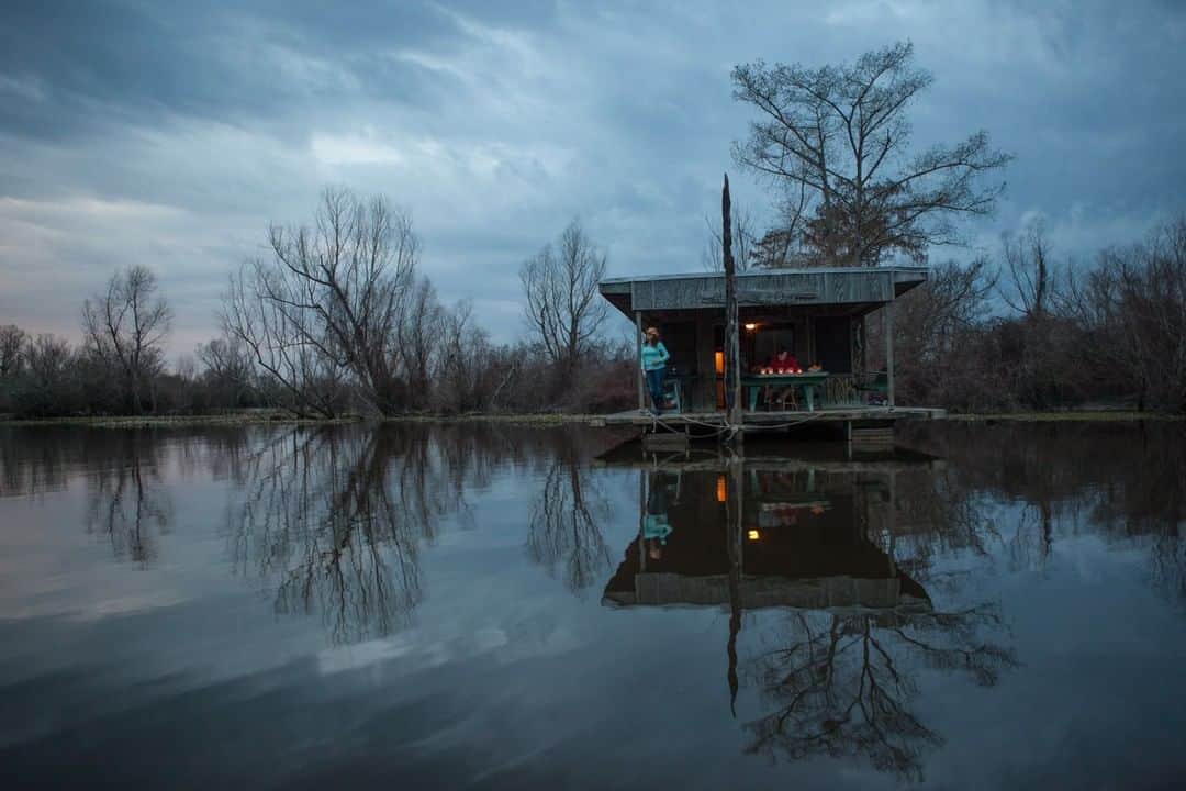 National Geographic Travelさんのインスタグラム写真 - (National Geographic TravelInstagram)「Photo by @hellokrisdavidson | The Atchafalaya River is a distributary of the Mississippi River, with its woods, fertile marshes, and meandering waters providing an essential habitat for countless flora and fauna. It is situated at the heart of Cajun country and steeped in culture and history. Sleeping in the Atchafalaya Basin feels a bit like time travel, or at the very least, like Indiana Jones caliber adventuring; one can’t help but wonder what lurks below the opaque, mirror surface, a Rorschach of sorts inviting introspection. Time seems suspended while sitting on the deck of the houseboat at dusk, beholding a scene that is haunting, mysterious, and completely beautiful. #NPS #cajuncountry」8月21日 17時02分 - natgeotravel