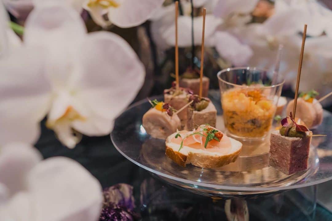 のインスタグラム：「.﻿ 「IDEO TOKYO Office」1st Anniversary Party﻿ ﻿ ﻿ IDEO様のTOKYO Office1周年パーティーのテーマは「ALL THAT JAZZ」﻿ ﻿ バンドがJAZZを奏でる中、FOODやお酒を片手に、カジュアルにコミュニケーションを楽しむ大人のPARTYに合わせ、GOLD＆BLACKをベースカラーに、フィンガーフードのブッフェやフォトブース、ドリンクカウンターをつくらせていただきました。﻿ ﻿ ﻿ 【MENU】﻿ ・鮭のテリーヌ 柚子と昆布のジュレ﻿ ・鶏肉のバロティーヌ 柑橘の香り﻿ ・パテ﻿ ・シーフードパエリア﻿ ・生ハム＆クリームチーズ＆セミドライトマトのオープンサンド﻿ ﻿ ﻿ ﻿ Photo by @ayatoozawa  Art Direction by @0130nao and @wsomeya  Flower by﻿ @shigeru_abe_florist ﻿ ﻿ ﻿ follow us!﻿ @crazy_kitchen_insta」