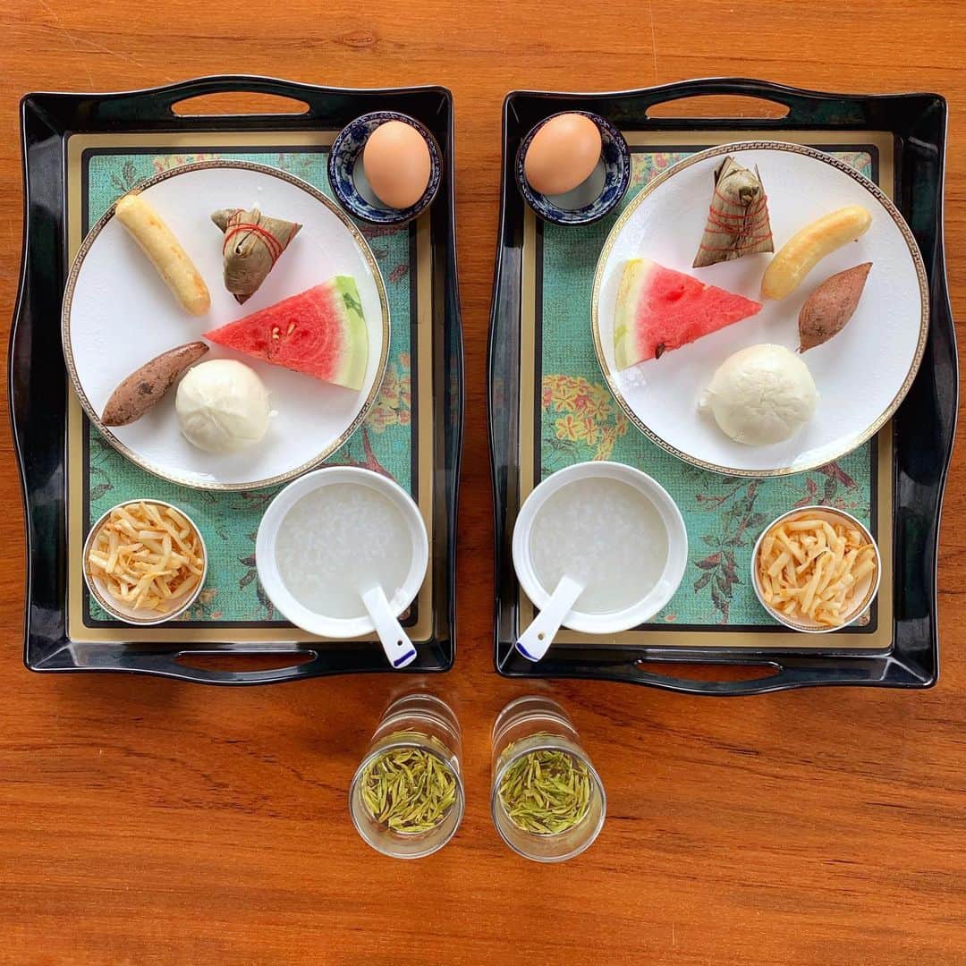 Symmetry Breakfastのインスタグラム：「A weekend away from Shanghai for my birthday at Qiandaohu 千岛湖 or Thousand Island Lake (about 2.5hrs by train) We are staying at a cute home stay/hostel called Fishman on Peilou Island. The lake was created in 1959 when they constructed the Xin’an dam, today it’s one of the cleanest lakes in the world and where Nongfu water comes from. - - - - - - - - - - - - - - - They asked us last night what type of breakfast we wanted, when I said 中国的早饭 Chinese style breakfast they were almost shocked! 😂 A hard boiled egg, some plain congee, pickles, melon, a sweet egg custard bao, a chicken sausage, a small steamed sweet potato and a zongzi 粽子 with some green tea. #symmetrybreakfast #chinesebreakfast #qiandaohu #thousandislandlake #zhejiang #china #中国」