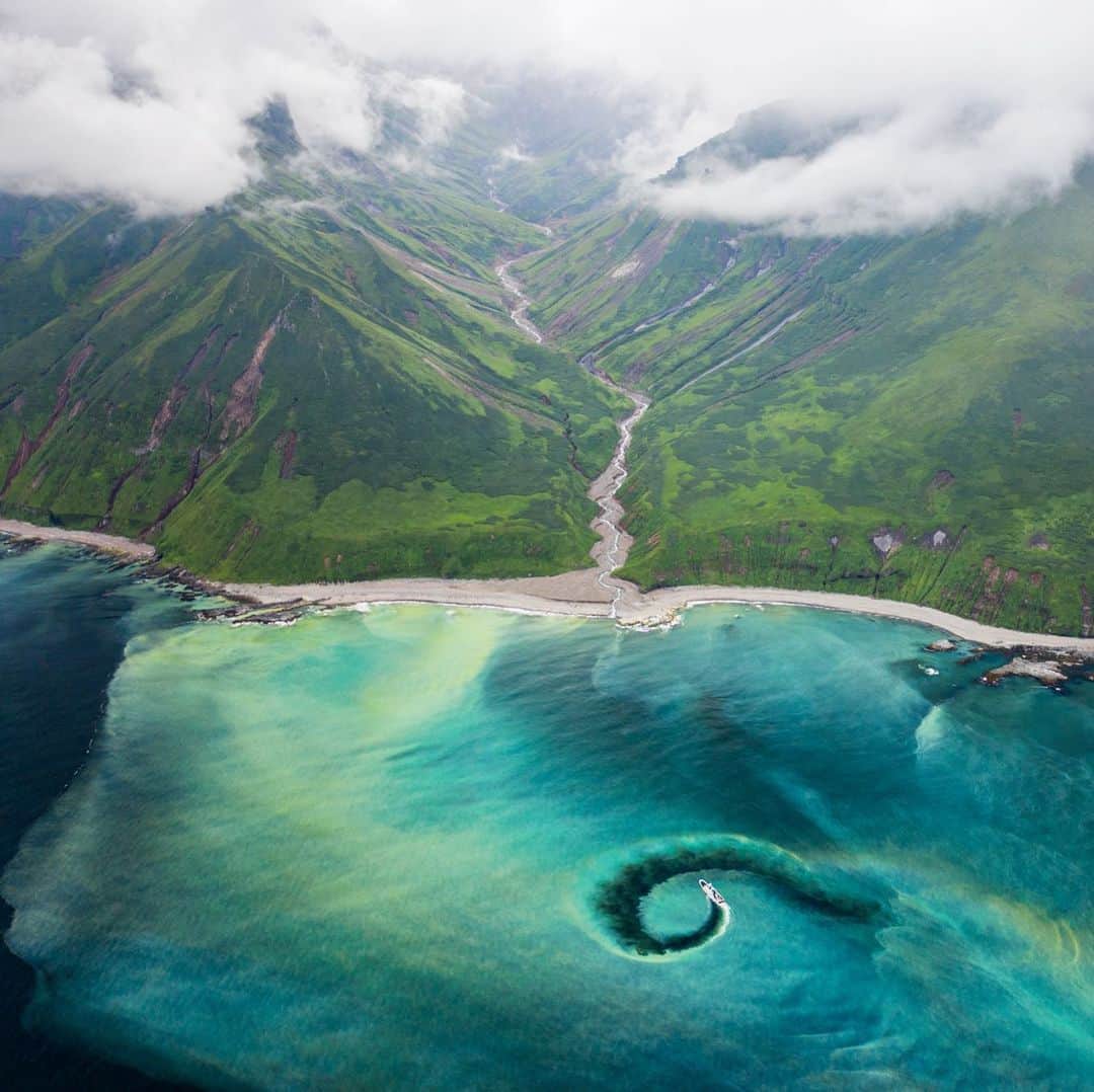 クリス・バーカードのインスタグラム：「We did a double take as the ocean turned to a milky green and our boat became surrounded by highly mineralized water emerging from a volcanic hot spring. From a drone the tributary becomes visible as this steaming river winds it’s way toward the ocean. I’ve never seen this water color skim surface like this before, I guess this is what they meant when they said the Kurils were full of mystery. #fromkurilswithlove」