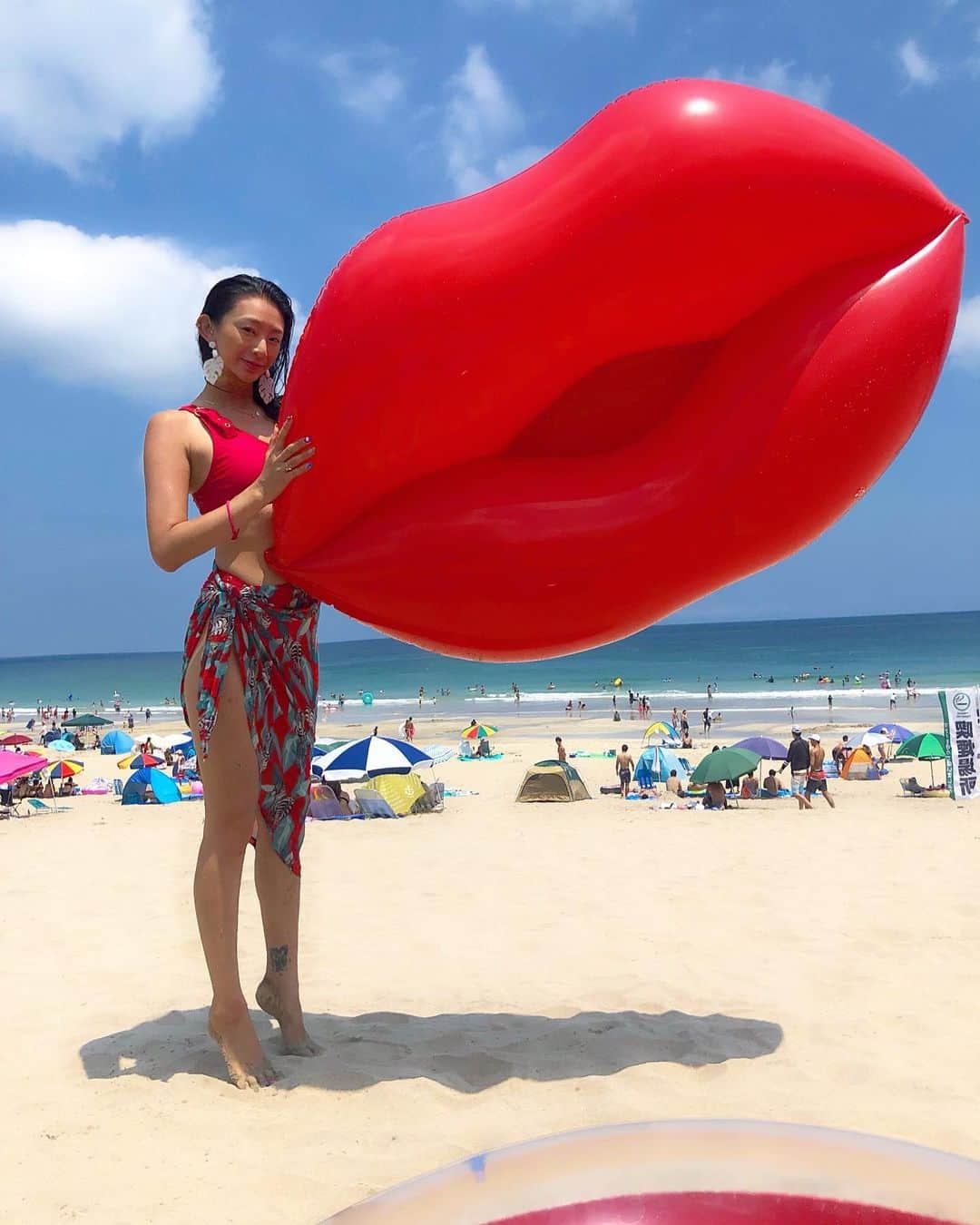 DJ JUICYのインスタグラム：「あ〜 もぅ〜海行けないかなぁ〜🏖💦 くちびるデッカくなっちゃった💋😆👂 って、何度もやりながら写真🤳🤣 シュールなのがツボww  風で飛ばされるし、ちょっとデカすぎて持つの大変だけど、、、愛着わいて可愛くなってくるんだよー😭  あーデッカいくちびるちゃん💋もう一回くらい使いたい😚❤️💙✨ #海 #夏 #💋 #beach#juicy#summer#裸足でもNIKE」