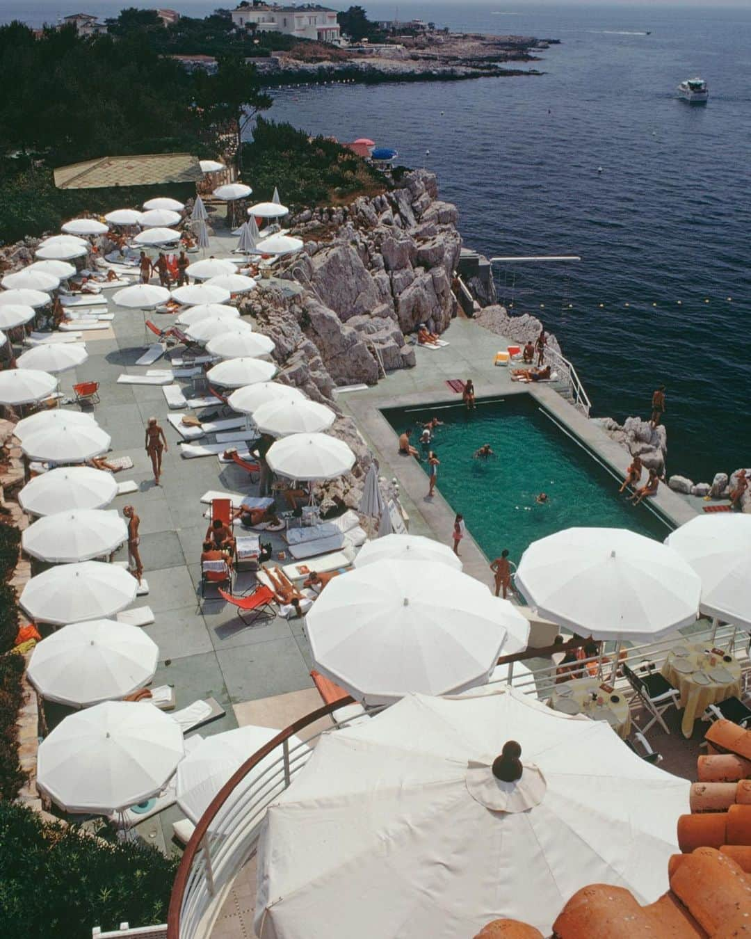 Vogue Parisさんのインスタグラム写真 - (Vogue ParisInstagram)「The Eden Roc hotel has become something of a legend as the HQ of the biggest stars during the Cannes Film Festival for decades. Photographer Slim Aarons was there in 1969 and captured this shot of the hotel’s iconic lagoon pool that looks out across the Mediterranean  #SlimAarons #EdenRoc @hotelducapedenroc」8月28日 17時43分 - voguefrance