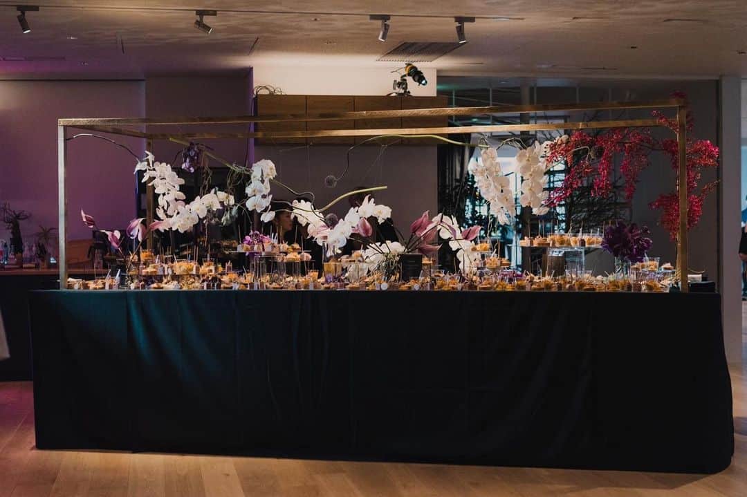 のインスタグラム：「.﻿ 「IDEO TOKYO Office」1st Anniversary Party﻿ ﻿ ﻿ IDEO様のTOKYO Office1周年パーティーのテーマは「ALL THAT JAZZ」﻿ ﻿ バンドがJAZZを奏でる中、FOODやお酒を片手に、カジュアルにコミュニケーションを楽しむ大人のPARTYに合わせ、GOLD＆BLACKをベースカラーに、フィンガーフードのブッフェやフォトブース、ドリンクカウンターをつくらせていただきました。﻿ ﻿ Photo by @ayatoozawa  Art Direction by @0130nao and @wsomeya  Flower by﻿ @shigeru_abe_florist ﻿ ﻿ ﻿ follow us!﻿ @crazy_kitchen_insta」