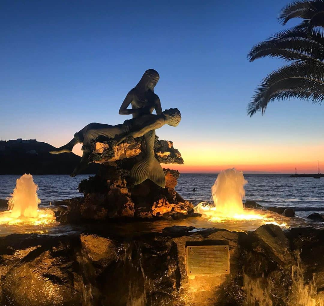 メラニー・サイクスさんのインスタグラム写真 - (メラニー・サイクスInstagram)「Goodnight and goodbye 💙This beautiful statue and fountain features a mermaid holding a fisherman. The statue is called Panagia Gorgona (which means Virgin Mary the Mermaid) and is the patroness of fishermen. It is a memorial to fishermen lost at sea. The sculpture was created by Giorgos Xenoulis of Athens and it is just lovely 💙💫 #syros #kini #greekisland #statue #sunset」8月30日 3時15分 - msmelaniesykes