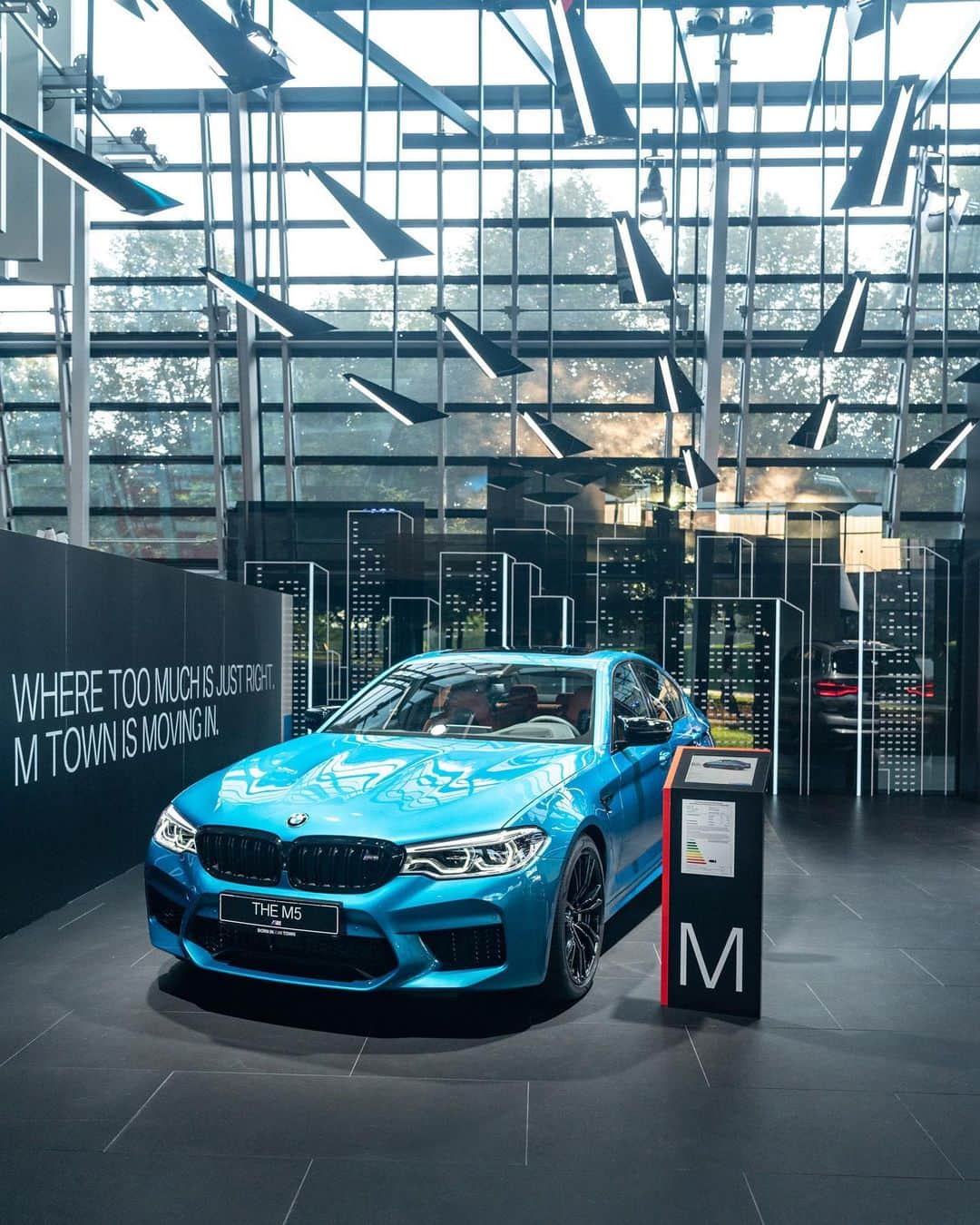 BMWのインスタグラム：「The virtual dream city of M Town came to life at BMW Welt. Who's moving in?  #TheX3M #TheX4M #BMW #BMWM #M_Town @bmwwelt __ BMW M5 Competition: Fuel consumption in l/100 km (combined): 10.6. CO2 emissions in g/km (combined): 241.  BMW M4 Convertible: Fuel consumption in l/100 km (combined): 10.2 [9.5]. CO2 emissions in g/km (combined): 232 [217]. BMW X3 M Competition: Fuel consumption in l/100 km (combined): 10.5. CO2 emissions in g/km (combined): 239.  BMW X4 M Competition: Fuel consumption in l/100 km (combined): 10.5. CO2 emissions in g/km (combined): 239.  The values of fuel consumptions, CO2 emissions and energy consumptions shown were determined according to the European Regulation (EC) 715/2007 in the version applicable at the time of type approval. The figures refer to a vehicle with basic configuration in Germany and the range shown considers optional equipment and the different size of wheels and tires available on the selected model. The values of the vehicles are already based on the new WLTP regulation and are translated back into NEDC-equivalent values in order to ensure the comparison between the vehicles. [With respect to these vehicles, for vehicle related taxes or other duties based (at least inter alia) on CO2-emissions the CO2 values may differ to the values stated here.] The CO2 efficiency specifications are determined according to Directive 1999/94/EC and the European Regulation in its current version applicable. The values shown are based on the fuel consumption, CO2 values and energy consumptions according to the NEDC cycle for the classification. Further information on official fuel consumption figures and specific CO2 emission values of new passenger cars is included in the following guideline: 'Leitfaden über den Kraftstoffverbrauch, die CO2-Emissionen und den Stromverbrauch neuer Personenkraftwagen' (Guide to the fuel economy, CO2 emissions and electric power consumption of new passenger cars), which can be obtained free of charge from all dealerships, from Deutsche Automobil Treuhand GmbH (DAT), Hellmuth-Hirth-Str. 1, 73760 Ostfildern-Scharnhausen and at https://www.dat.de/co2/.」