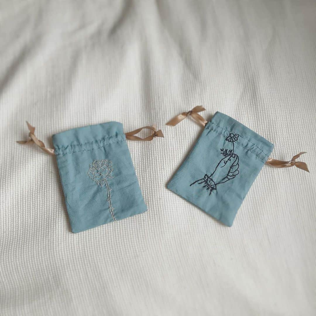 真山朔のインスタグラム：「最近のマイブームが巾着なので、ミニ巾着にしたのだけど、刺繍した後に何も考えずに布切ってしまって、一番見えて欲しい刺繍の部分が絞られて見えないという笑えるミスをしちゃった。 左の薔薇はギリギリセーフ…？？ 図案はどちらも、蓬莱和歌子さんの『装う刺繍身につける刺繍』からです。  #刺繍 #巾着」