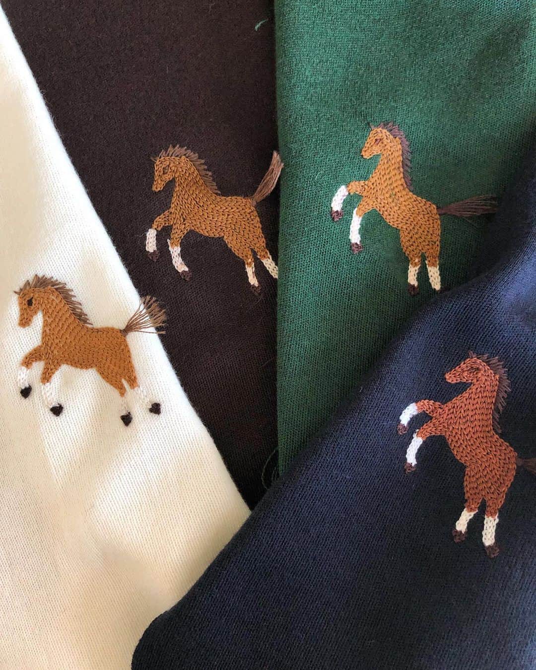 のインスタグラム：「・ ストーリーでも反響がすごく大きかった馬の刺繍カーディガン🐴 オフ、ダークブラウン、グリーン、ネイビーの4色です。 太い糸を使ったチェーンステッチは刺繍の熟練工場にお願いし、手刺繍のような繊細で難しいディテールを機械刺繍で表現しています✨しっぽのフサがチャームポイント。 馬モチーフ好きで、インテリアも馬が何頭いるんだ、という感じの私の趣味で作りましたが反響が大きくて嬉しい❤️ かねてから作りたかった馬のプリントも作っちゃおうかな🐴 入荷は10月下旬予定✔︎ ・ あ、そうそうグリーン以外は五分袖タートルを同じ色で用意してるのでアンサンブルで着るのおすすめ❤️」