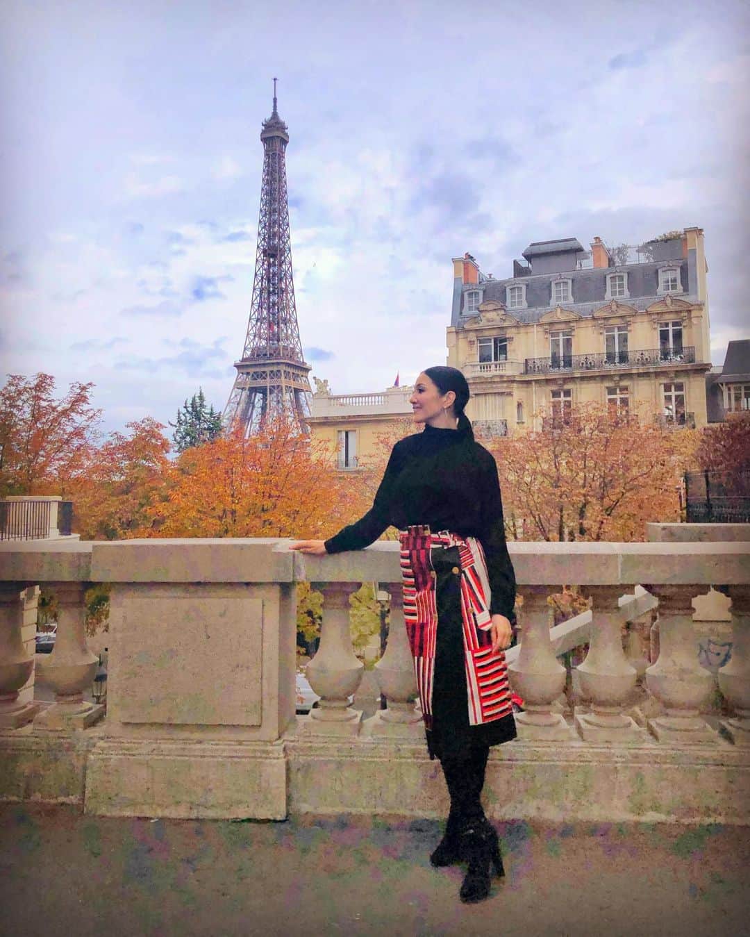 のインスタグラム：「Parisに到着✈️ 🇫🇷 エッフェル塔と秋の木々が美しい場所で撮影📸 2020 S/S パリコレを楽しみレポートします👠✨ 。 #個性あるスカートは黒で挟むとステキにまとまる トップス スカート  #moga_bigi_official  ロングブーツ  #jimmychoo  ピアス  #grosse  #fashion #ootd #pariscollection #model #ahnmika」