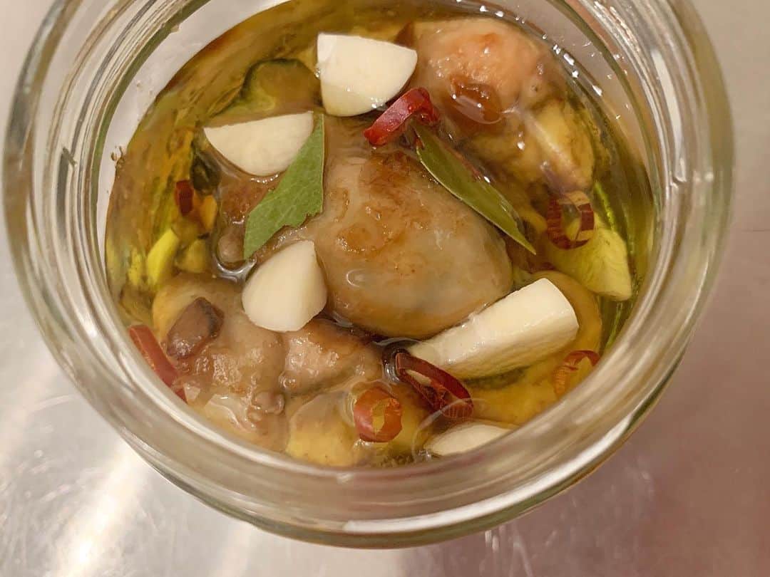 持永真実のインスタグラム：「.﻿ 🐚牡蠣のオイル漬けの作り方💁🏻‍♀️﻿ ﻿ 用意するもの﻿ ・加熱用牡蠣(冷凍でも可)﻿ ・オイスターソース﻿ ・にんにく ひとかけ﻿ ・唐辛子 ひとつまみ﻿ ・ローリエ 1-2枚﻿ ﻿ 作り方﻿ ①冷凍の牡蠣を半解凍します﻿ 🅿︎全部解凍すると旨味成分まで流れ出てしまうので﻿ 外側が解凍されればOK﻿ ﻿ ②キッチンペーパーで水気を取ります﻿ ﻿ ③くっつかないようにオリーブオイルを引いた﻿ フライパンに牡蠣を並べます﻿ ﻿ ④強火で火をかけると水分が出てグツグツと白く濁ります﻿ 🅿︎くっつかないようにフライパンをゆすりながら火を通します﻿ ﻿ ⑤火が通ったら弱火にしてオイスターソースで味付けます﻿ ﻿ ⑥フライパンから上げて粗熱をとります﻿ ﻿ ⑦瓶ににんにく、唐辛子、ちぎったローリエと﻿ 牡蠣を交互に敷き詰めていきます﻿ ﻿ ⑧全体がかぶるところまでオリーブオイルを注ぎます﻿ ﻿ ⑨冷蔵庫で冷やしながら一晩おけば完成！﻿ ﻿ ﻿ ローリエは生臭さを取ってくれるので入れましょう！﻿ ブラックペッパーやコリアンダーなどのスパイスやハーブ﻿ を入れても良し🙆‍♀️﻿ ﻿ ﻿ ﻿ お店で初めて牡蠣のオイル漬けを食べた時感動しました🥺﻿ ﻿ お店ではちょっとしか食べれないから﻿ わたしは楽天で冷凍牡蠣の大袋を買って作ってます(笑)﻿ ﻿ 食べるの楽しみだなぁ💕﻿ ﻿ ワインをあけたくなる〜😆🍷🍾」