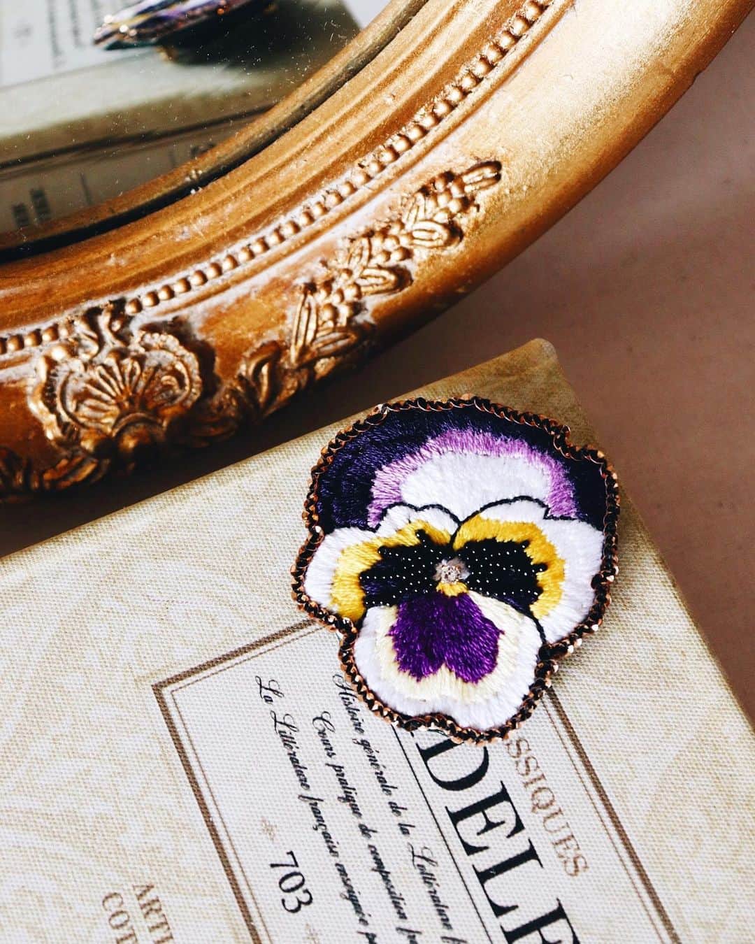 handmade shopのインスタグラム：「online shopオープン中です🌜﻿ ﻿ 本日の9/9(月)23:59までご注文いただけます﻿ ﻿ ﻿ 刺繍糸、ビーズ、フランス製のスパンコールを﻿ 使用した色彩豊かなパンジーのブローチ﻿ ﻿ パキッとしたカラーリングが印象的で﻿ パープル使いがどことなく上品な雰囲気です﻿ ﻿ 一針一針、丁寧に時間をかけて作り上げました ﻿ ﻿ ﻿ online shopでは月を追うごとに﻿ 色を入れ替えたり、新しいデザインを投入したり﻿ していこうと思っています◯﻿ ﻿ 9月だけの販売となる﻿ お花もありますので﻿ ぜひお見逃しなく﻿ ﻿ プロフィールのリンクからご覧ください」