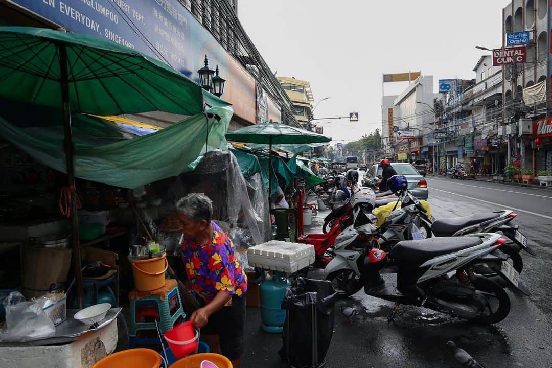 Shunsuke Miyatakeのインスタグラム：「A smoking mom at a street vendor.  So many people say Khaosan has lost their soul. Actually it is full of Fast Food Restaurants same as other cities, and most of street vendors are gone. But there are still strong tuk-tuk tricycle drivers, street vendors selling from fried insects to decorative frogs that squeak, and a drunk man who makes a noise while wandering through this long street until late at night. I love a rough, rugged and cosmopolitan atmosphere like her. #hellofrom Bangkok.」