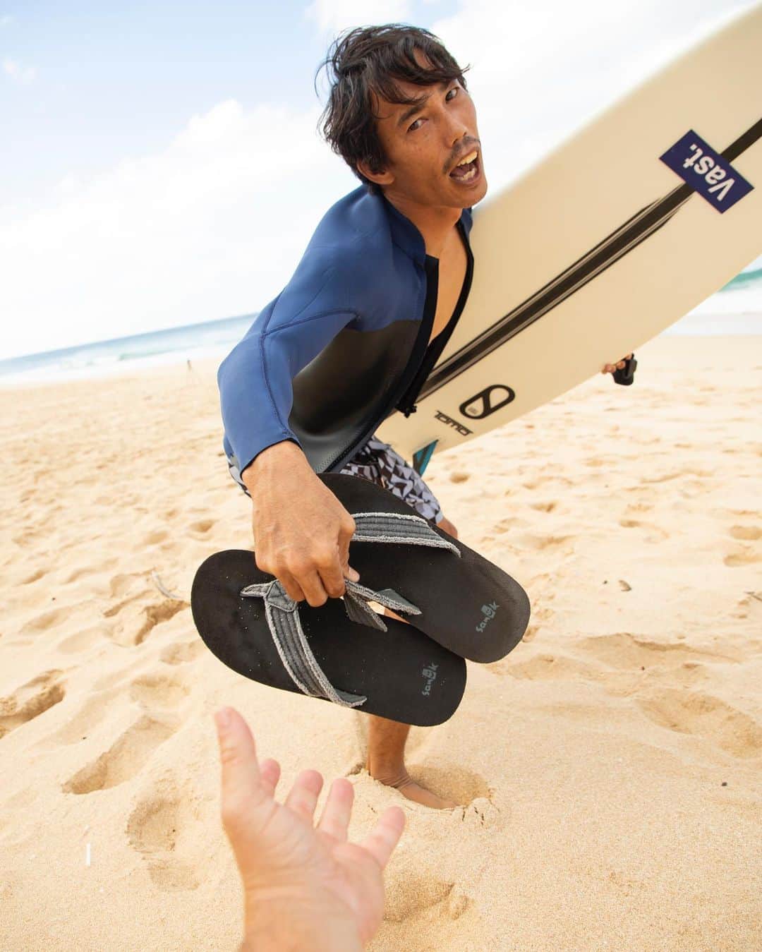 のインスタグラム：「“Hold da slippahs, cuz. Out there!” @Macy__Mullen, making sure no one steals his favorite Sanuks while surfing. #Sanuk #SmilePassItOn」