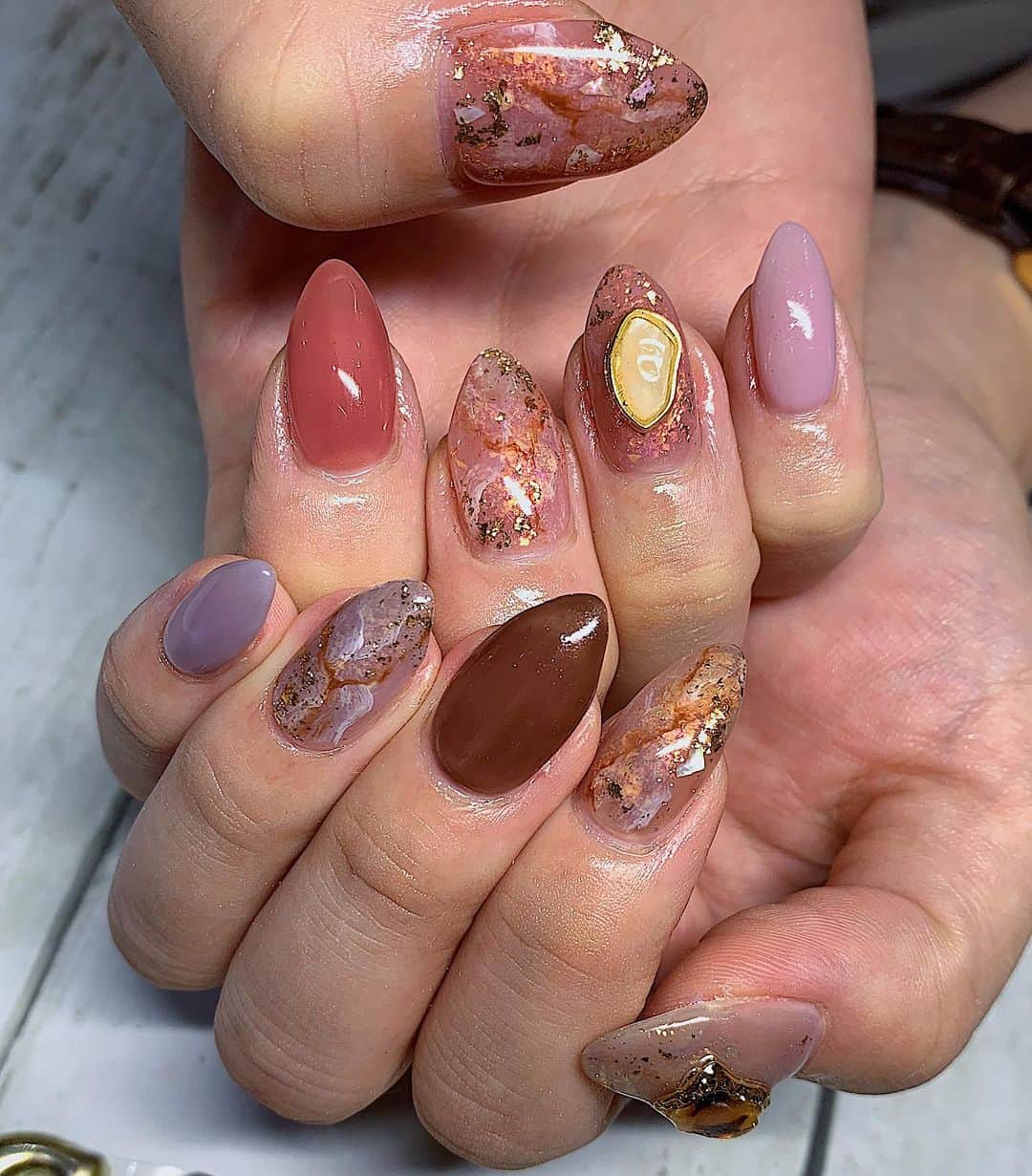 Minaのインスタグラム：「今晩は💗 ・ 今回のNew nail💅 ・ 載せるの遅くなってしまった😭💦 参考にしたいと言って下さったフォロワー様😭🙏 本当に遅くなってすみません😭🙏 ・ ・ 今回も大好きな天然石ネイル💅✨✨ ・ 秋を意識してカラーをグレー、ブラウン、ピンク、濃いピンクをカラーに入れてもらったの🥺💗 ・ 色味も作ってくれたんだけどめっちゃドンピシャ😍💕 ・ 天然石のところにはオーロラ？と金粉？みたいなのをポンポン付けてくれて✨✨ キラキラ大好きなあたしにとって可愛すぎてキュンキュンしちゃう🥺💗 ・ キラキラで可愛いけど大人っぽくて、秋らしいネイル💅🍁💍✨💕 ・ どタイプでずっとニマニマしちゃう🤤💗💗💗 ・ パーツは乗せ過ぎないようにあえてインパクトあるのを1つずつ乗せてそれぞれの爪の可愛いさが目立つようにバランス良く😚 ・ もー大満足です🤩 また似た感じに次もしてもらいたーい💗 ・ ・ 今日も見て頂きありがとうございました🥰 ・ ・ ・ #nail #nailsalon #nails#ネイル#ジェルネイル#秋ネイル#ブラウンネイル#大人かわいい #大人ネイル#お洒落ネイル#アシンメトリーネイル#天然石ネイル#ネイルデザイン #ネイルアート#池袋ネイルサロン#ニュアンスネイル#トレンドネイル#キラキラネイル#お洒落さんと繋がりたい #美容#美容大好き#大人女子ネイル」