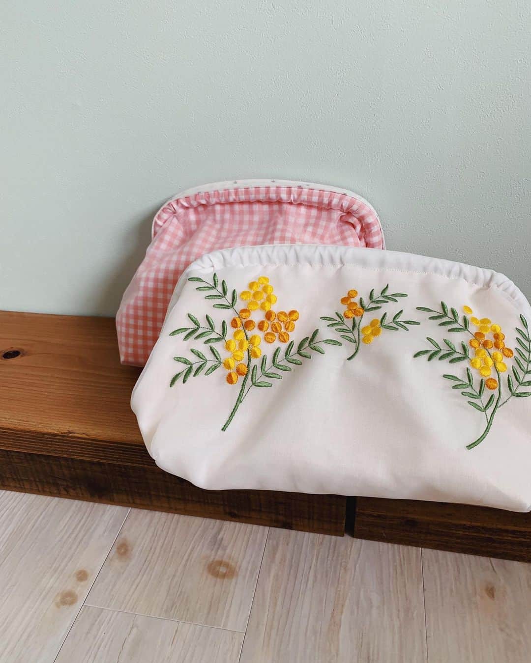 のインスタグラム：「前から素敵だなぁ〜と思っていた @silbege さんの刺繍達...🌿 . 今回orderさせてもらいました✍️ . . ミモザが素敵なオーガンジークラッチバッグとムスメの名前と裏側には出生体重と生まれた日付の入ったギンガムバッグ。 . どちらも本当素敵で届いた瞬間感動した... . 改めて私もそんなブランドでありたいと思った瞬間でした。 . 更に🍙のpresentまで... . そのちかさんの人柄が作品に出る。。。 . ありがとうございました🗣 大事にします♡ . #ポーチ #bag #細かい手仕事」