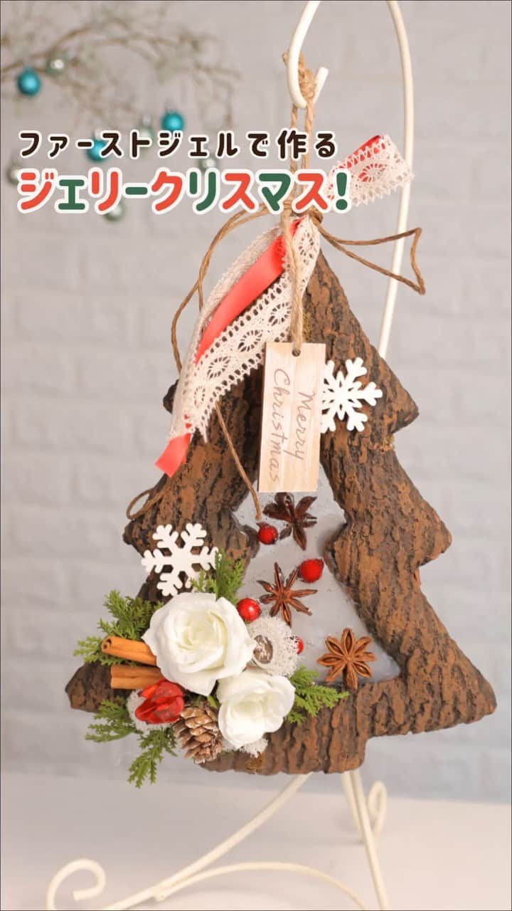 東京堂アーティフィシャルフラワーMAGIQのインスタグラム：「・ 今年はやりの透明資材で、 クリスマスアレンジを作ってみませんか？ ・ ファーストジェルで ツリーをデコります🌲✨ 名付けて、💠ジェリークリスマス💠 ・ 雪が溶けたような透明感のあるアレンジ❄️ 暑さが残る今の季節からも飾れます⛄️🍁 ・ 中は一体どうなってるの🎅🏻!? ついつい興味がわく作品です。 ・ ・ ・ 材料 【メイン資材】 MN 000FG1 ファーストジェル XU 124 フラットツリーフレーム GI 9 色1 クリスタルサンド オイルクレヨン白 ・ 【アーティフィシャルフラワー】 FM 8659 色1 プリティカローズピック FX 117 レッドベリーピック FG 302 ショートサイプレスピック ・ 【ドライ・プリザーブド】 DO 21020 色0 スターアニス DO 21050 色0 シナモンスティック4cm DO 24800 色982 ユーカリの実 DO 24430 色300 フヨウの実 DO 61151 色11 フィンランドモス ・ 【他資材】 XO 1613 ホワイトスノーパーツ XO 1890 ウッドタグオーナメント RT 45714 色25 ロービキ麻コード RA 651 色19 テラン RA 1160 色86 ベリータ ・ ・ ・ #TOKYODO#MAGIQ#MAGIQのある暮らし#東京堂#アーティフィシャルフラワー#アーティフィシャル#アートフラワー#造花#花のある暮らし#花のある生活 #花好きな人と繋がりたい#フラワーデザイン#フラワーアレンジメント#フラワーアレンジ#花が好き#花を飾る#クリスマス#christmas#artificialflower#クリスマスツリー#ファーストジェル#ジェリークリスマス #flowerofinstagram #flowerson instagram #花藝#插花#花藝課#保鮮花」