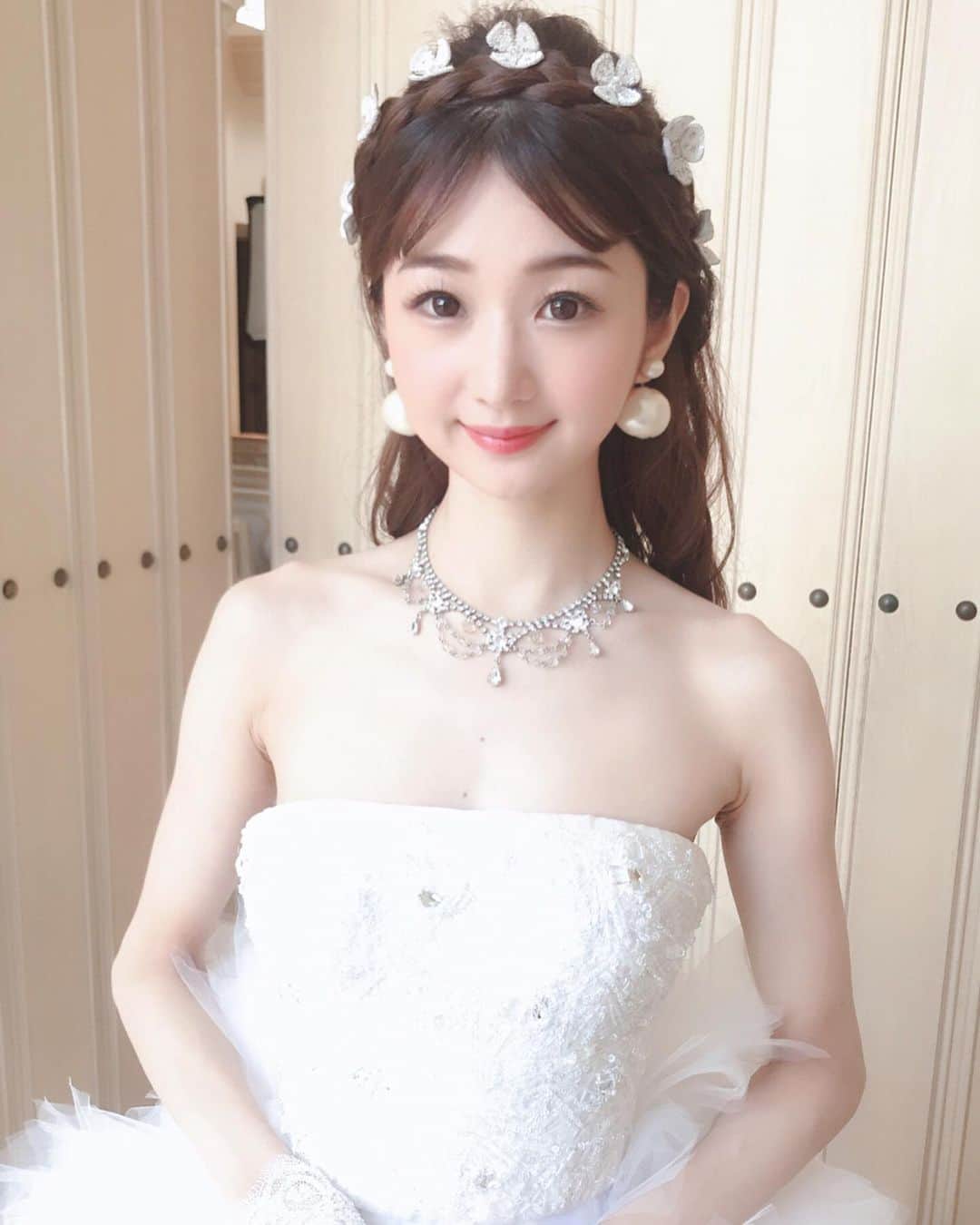 奈々子のインスタグラム：「このドレスの時だけ、ヘアは #エリザベート 風にしてもらいました♡ 似たような感じの髪飾りを散らしてもらい、編み込みのハーフアップに♪ 前髪は長さがないので短いセンター分け☆ 前髪をカールできたら完璧でした(*^_^*)♪ . #小顔ピアス はパールオンリーのタイプを合わせましたよ。^_−♡ . 最後の写真は表情が固くて昔の絵みたいになりました。（≧∇≦）笑 . . #ブライダル撮影 #エリザベートヘア #ビードレッセ #ビードレッセ名古屋 #bridalmodel #elisabeth #n75jewelry #n75小顔ピアス」