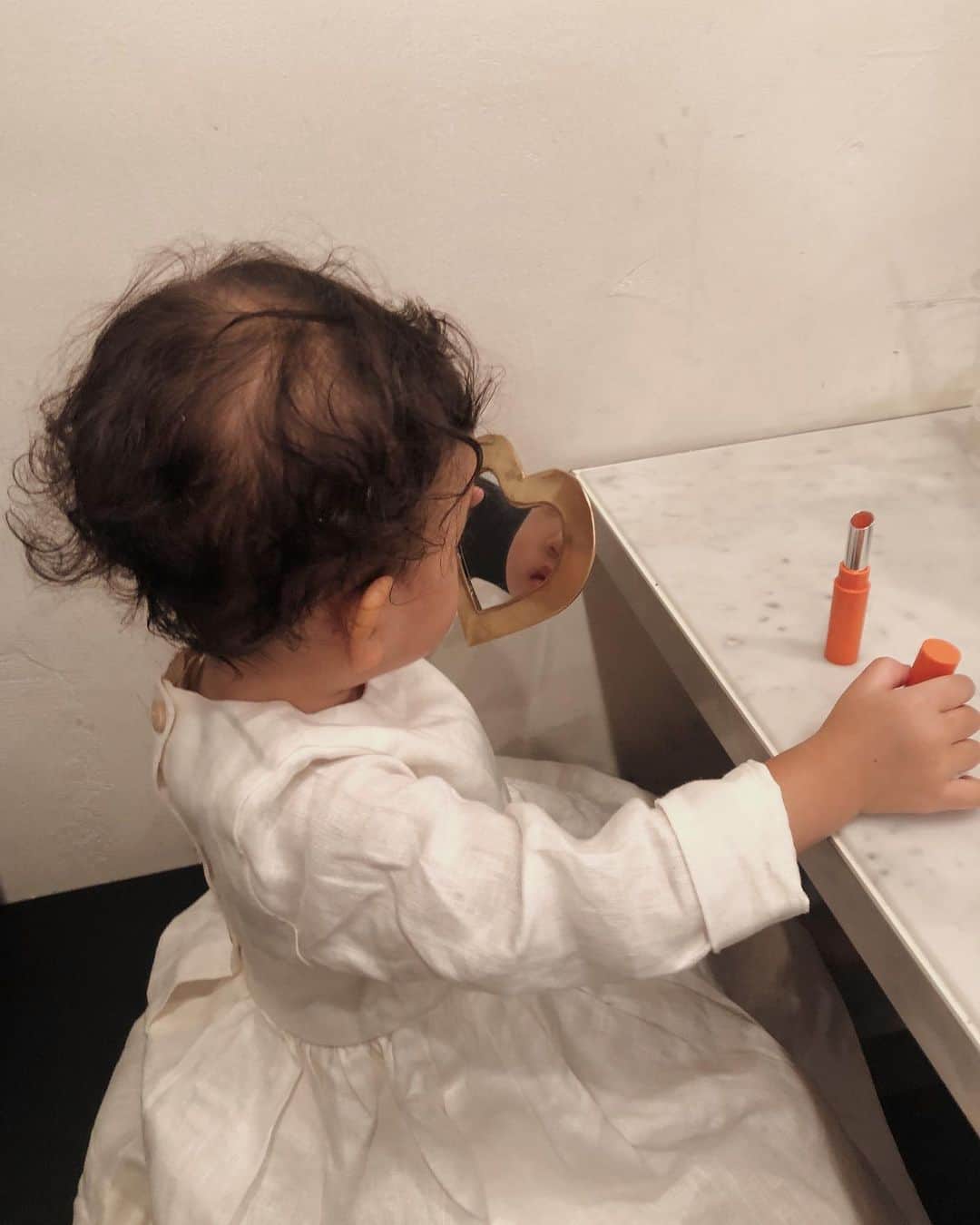目見田早弥子のインスタグラム：「| mini me👶🏻💛 私がリップ塗っているのを見つけると 「👶🏻も？👶🏻も？ぴっぷ、ちゅ！(リップ、する)」 と言って、まるで私のように 手鏡を持ってリップをぬりぬりする娘。 リップはつかないように 半分ほど使っているものを 最大限しまった状態で渡しています😂 この姿が愛おしい🧡💛 #1y9m」