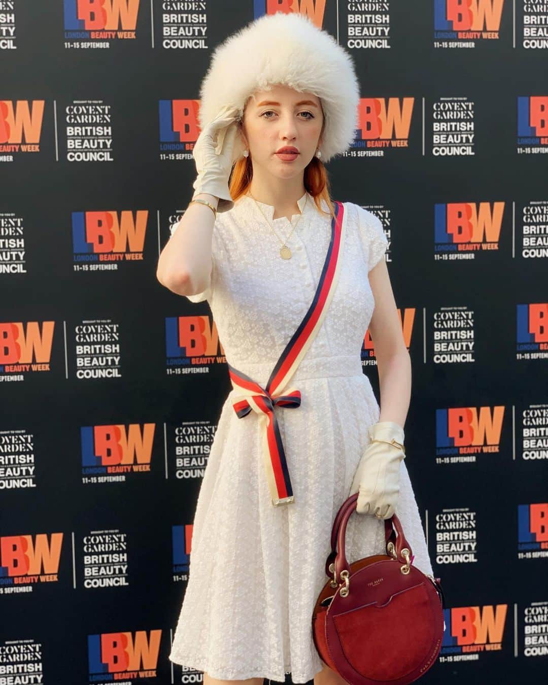 ベッキー・クルーエルのインスタグラム：「princess diaries 💋 my look for #LFW this year 🦋⁣⁣ ⁣⁣ 👗 My dress is from many years ago @stylewe gifted⁣⁣ ⁣⁣ 🇮🇲 My hat is a sheepskin charity shop £6 steal back home on the Isle of Man⁣⁣ ⁣⁣ 🧤 My gloves are £4 from a charity shop in Bristol⁣⁣ ⁣⁣ 👑 My necklace is an heirloom sovereign that was my birthday gift this year ⁣⁣ ⁣⁣ 👜 My sash is the strap of a Gucci Sylvie bag ⁣⁣ ⁣⁣ 💍 My earrings and ring are from @accessorize, who do the best gold plated and freshwater pearl jewellery at the moment!⁣⁣ ⁣ 👠 My bag is from @ted_baker and was a Christmas gift this year!⁣ ⁣ 👡 My shoes are simple @primark⁣ ⁣ ⁣ ⁣ #lfw #fashion #londonfashionweek #london #streetstyle #fashionweek #fashionblogger #ootd #style⁣」