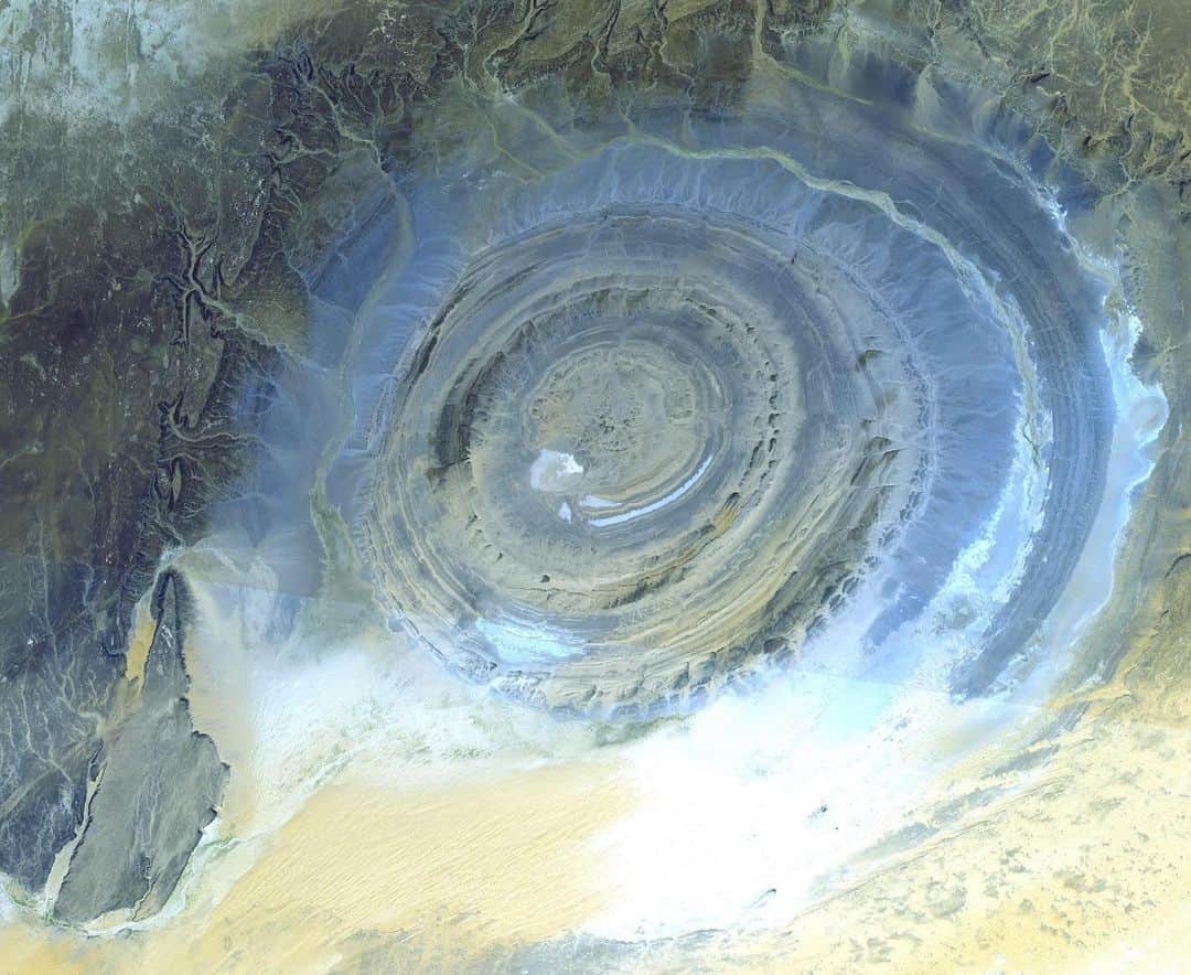 NASAさんのインスタグラム写真 - (NASAInstagram)「"The living history of the Earth jumps out at you through buckles, folds, giant fans," wrote astronaut Nick Hague (@astrohague) about his photo of the "Eye of the Sahara" from the International Space Station (@ISS). Scroll through for more images of this striking geologic feature, the Richat Structure of Mauritania, captured by astronauts on the station and @NASAEarth satellites. ⁣ ⁣ Located in the Sahara Desert, it measures 28 miles (45 kilometers) across and is made up of igneous and sedimentary rocks. It's thought to be caused by an uplifted dome that has been eroded to expose the originally flat rock layers.⁣ ⁣ #mauritania #sahara #desert #richatstructure #geology #earthart #spaceart⁣ ⁣ 1) Photograph taken from the International Space Station, Sept. 2019. The image has been enhanced to improve contrast.  Image Credit: NASA⁣ 2) ASTER Mission image from Oct. 7, 2000. Image Credit: NASA/METI/AIST/Japan Space Systems and U.S./Japan ASTER Science Team⁣ 3) Landsat satellite image draped over an elevation model produced by the Shuttle Radar Topography Mission (SRTM); February 2000 (SRTM), January 13, 1987 (Landsat). Image Credit: SRTM Team NASA/JPL/NIMA⁣ 4) Landsat-7 satellite image from Jan. 11, 2001. Image Credit: NASA/U.S. Geological Survey/Landsat-7/Goddard Space Flight Center⁣ 5) Photograph taken from the International Space Station, Dec. 17, 2011. Image Credit: NASA」9月18日 4時15分 - nasa