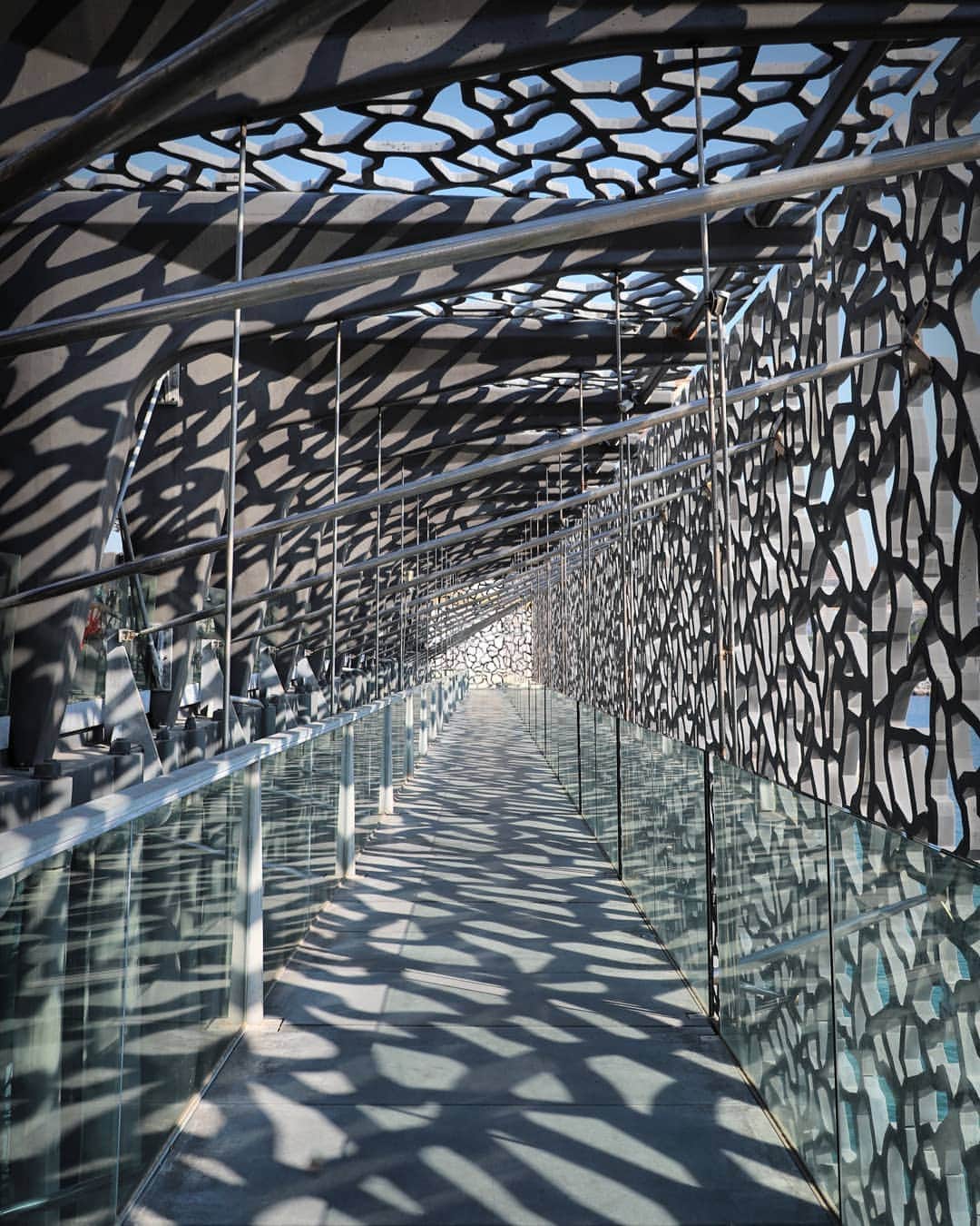 Rich McCorさんのインスタグラム写真 - (Rich McCorInstagram)「AD| Continuing my images from around France earlier this year I also ventured down to Marseille to visit @mucem_officiel, an unashamedly bizarre and eye-grabbing structure next to the harbour. I’d seen images of the museum online and I thought they were renders because it’s intricately designed shell looks surreal but the whole thing is very real including the gravity defying 130m long bridge (reimagined as a plank here) that links the museum to Fort Saint-Jean. I’m usually all for a wander around a museum but I only briefly spent time inside because it was the exterior that fascinated me, even more so at dusk when tiny blue lights in the latticework begin to sparkle and dance on the Mediterranean waters below #ExploreFrance #Mucem #Marseille」9月20日 20時07分 - paperboyo
