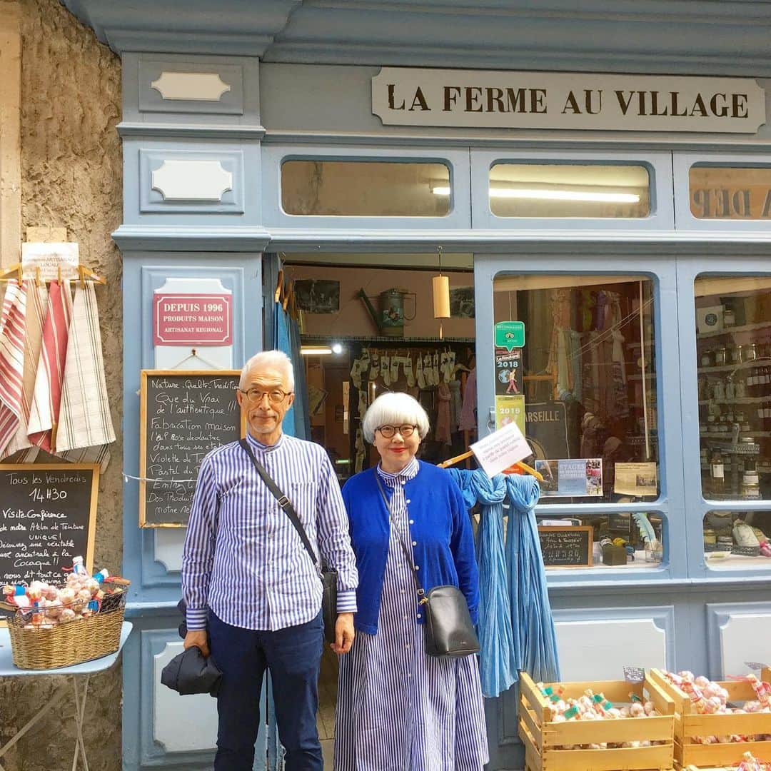のインスタグラム：「南フランス オクシタニー地方の旅🇫🇷 9月13日(金) これから先の旅の間、ずっとお世話になる現地ガイドのノブコさんがホテルに迎えに来てくださいました。ここから先はノブコさんが運転する車での移動となります🚙 ロートレックへ向けて出発。 ・ 《ロートレック Lautrec》 オクシタニー地方のちょうど真ん中に位置する小さな街。中世の建物が残る、のどかな街です。「フランスの最も美しい村」にも選ばれました。 ・ 【パステル工房La Ferme Au Village】 中世から16世紀にかけて、パステルの葉を用いて青色を作ることが行われていました。当時のパステル商人は国王よりも裕福だったといいます。そんなパステルの栽培と染色の様子を見学することができました。 パステルの青に合わせて、この日は青コーデにしました💙💙 パステルの染料には防虫効果もあるそうで、衣類の他に建物の塗料としても使われたそうです。 パステルというと画材しか知らなかったので、目からウロコでした😳😳 ・ ランチ：La Ferme Au Village 特産物であるバラ色のニンニク（Ail Rose de Lautrec）をふんだんに使ったスープをいただきました。 大きな器にたっぷり運ばれてきたニンニクスープ🥣とてもまろやかで優しい味でした。 生ハムのサラダやチキンのお料理もとても美味しかったです😍😍 ・ 小さな村にも立派な教会がありました⛪️ ・ ロートレックに向かう前に、林の中に佇む紙作りの工房を訪ねました。(8〜10枚目) 【紙作り工房 Le Moulin à Papier de Brousses et Villaret】 カルカッソンヌから車で約20分、林の中にたたずむ水車小屋。ここでは、7世代にわたって紙作りが営まれてきました。色のついた布や、様々な種類の植物の繊維を用いて、色の付いた紙を作ります。工房内では、原料の準備に使う打解器やビーターなどの大型機械が見られました。また、紙でできたドレスも展示されていました。日本人のアーティストともコラボしているそうです。 ご主人がひとつひとつ丁寧に説明してくださいました。和紙の作り方にも似ていますが、原材料や漉き方に特徴がありました。 近隣の子供達が、紙作りの体験学習に訪れているそうです。 ・ @Tourisme_en_Occitanie ・ ・ #TourismeOccitanie #TourismeTarn #フランス観光開発機構 #南フランス #オクシタニー地方 #ロートレック #夫婦 #60代 #ファッション #コーディネート #リンクコーデ #夫婦コーデ #グレイヘア #白髪 #共白髪 #couple #over60 #fashion #coordinate #instafashion #instagramjapan #greyhair #bonpon511 ・ つづく」