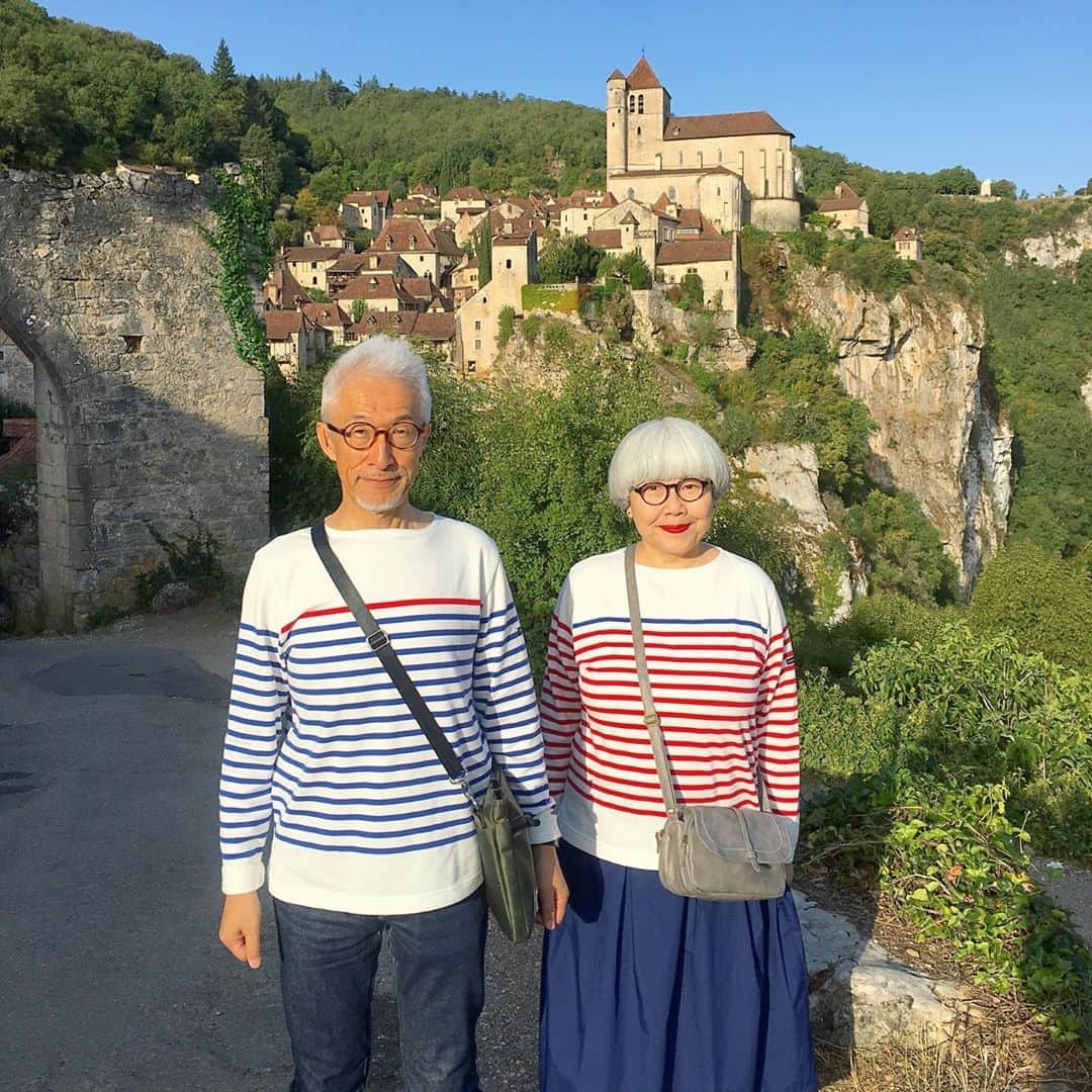 のインスタグラム：「南フランス オクシタニー地方の旅🇫🇷 9月15日(日) 《サン・シル・ラポピー Saint-Cirq-Lapopie》 「フランスで最も美しい村」の一つ。切り立った断崖に張りつくようにして中世の家々が立っています。村の城跡まで上ると緑の田園風景と蛇行するロット川が見晴らせます。土産物屋やアーティストのギャラリーはたくさんありますが、村の景観を守るため、売店が外に張り紙をしたり商品を展示することは厳しく規制されています。 ＊ まるでおとぎの国に迷い込んだような可愛らしい村🏡🏠 ファンタジー映画に出てきそうな雰囲気にワクワクしました😍😍 この日のコーデは、G.F.G.S. × bonponコラボのボーダーで。( @gfgs )ちょうどトリコロールカラーなので、今回のフランス旅でぜひ着てみたいと思っていました💙❤️ ・ 【サン・シル教会】 村の中心でひときわ高いロマネスク様式の塔。中はシンプルなステンドグラスと主祭壇です。 ・ @Tourisme_en_Occitanie ・ ・ #TourismeOccitanie #tourismelotdordogne #visitsclapopie #valleedulot #フランス観光開発機構 #南フランス #オクシタニー地方 #サンシルラポピー #夫婦 #60代 #ファッション #コーディネート #リンクコーデ #夫婦コーデ #グレイヘア #白髪 #共白髪 #couple #over60 #fashion #coordinate #instafashion #instagramjapan #greyhair #bonpon511 ・ つづく」