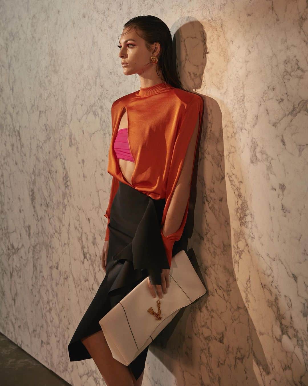 ジャンニヴェルサーチさんのインスタグラム写真 - (ジャンニヴェルサーチInstagram)「Fire orange slashed knitwear with sculptured shoulders is paired with an asymmetric silk satin skirt, delicate strap sandals and a #VersaceVirtus clutch bag. #MFW  _ Photos by @gregswalesart」9月23日 5時40分 - versace