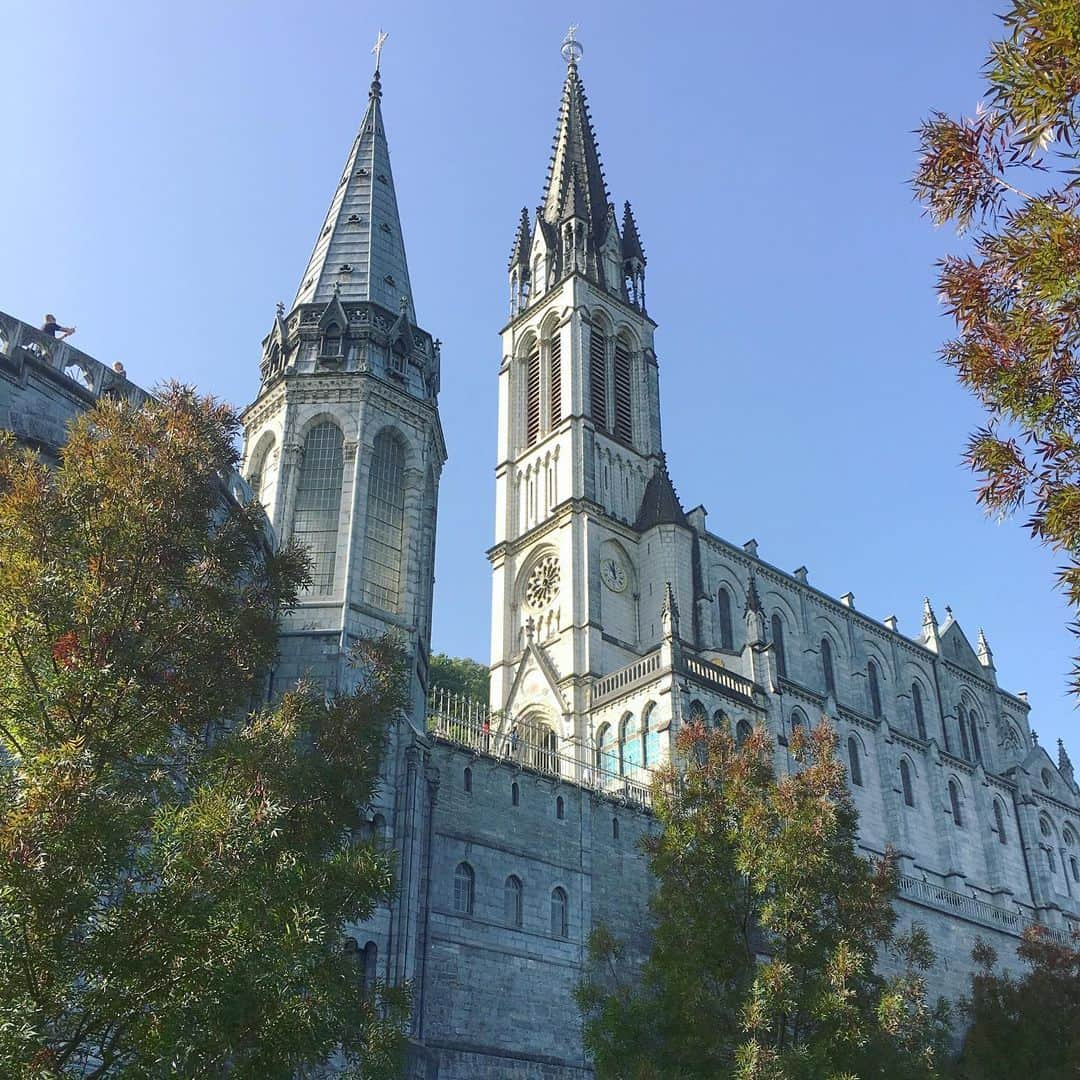 bon ponさんのインスタグラム写真 - (bon ponInstagram)「南フランス オクシタニー地方の旅🇫🇷 9月17日(火) 《ルルド Lourdes》 1858年2月11日、ポー川のほとりにある洞窟の近くに薪を集めに来た14歳の少女ベルナデット・スビルーの前に聖母マリアが現れました。合計で18回、聖母マリアはベルナデットの前に出現し、泉へ行って水を飲み、顔を洗いなさいと命じました。洞窟近くの地面を掘ると泉がわき始め、その湧き水によって病気が治癒する奇跡が何度も起きたといいます。ルルドは170か国から年間600万人が集まるカトリック最大の巡礼地となりました。 ＊ 旅の最終日に念願のルルドへ行くことができました。 フランス国内で、ルルドはパリに次いでホテルの数が多いそうです。それほど多くの巡礼者が訪れていることに驚きました。 聖域の外は、土産屋が立ち並びとても賑やかですが、聖域に入ると一転して厳かな雰囲気に満ちていました。 そこに自分達が立っていることに、言葉では表せない感動に包まれました🙏✨ ・ 【マッサビエルの洞窟】 聖母が出現したとされる洞窟。奇跡の泉はマリア像の左下奥にあり、今も泉がわいています。 ＊ 岩に触れ伝いながら、泉の湧くところへ進んで行きました。 ガラスに覆われて直に触ることはできませんが、洞窟の右手に泉の水を汲む場所がありました。ボタンを押すと水が出ます。この水は、顔を洗うことも飲むこともできます。 清きものとなれますように… ・ ロウソクを奉納して、聖堂へ。 ・ @Tourisme_en_Occitanie ・ ・ #TourismeOccitanie #DestinationPyrenees #Lourdes #フランス観光開発機構 #南フランス #オクシタニー地方 #ルルド　#夫婦 #60代 #ファッション #コーディネート #リンクコーデ #夫婦コーデ #グレイヘア #白髪 #共白髪 #couple #over60 #fashion #coordinate #instafashion #instagramjapan #greyhair #bonpon511 ・ つづく」9月23日 20時47分 - bonpon511