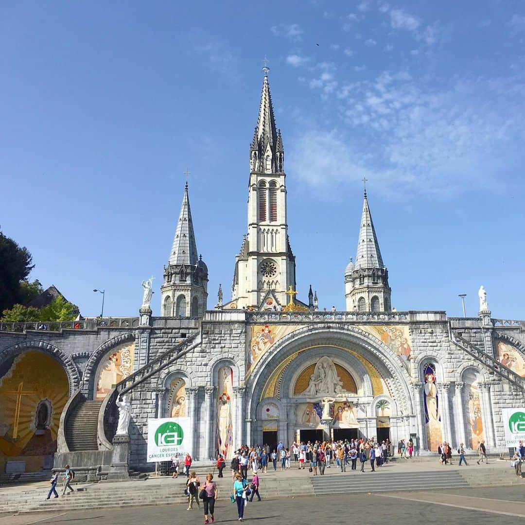 bon ponさんのインスタグラム写真 - (bon ponInstagram)「南フランス オクシタニー地方の旅🇫🇷 9月17日(火) 《ルルド Lourdes》 1858年2月11日、ポー川のほとりにある洞窟の近くに薪を集めに来た14歳の少女ベルナデット・スビルーの前に聖母マリアが現れました。合計で18回、聖母マリアはベルナデットの前に出現し、泉へ行って水を飲み、顔を洗いなさいと命じました。洞窟近くの地面を掘ると泉がわき始め、その湧き水によって病気が治癒する奇跡が何度も起きたといいます。ルルドは170か国から年間600万人が集まるカトリック最大の巡礼地となりました。 ＊ 旅の最終日に念願のルルドへ行くことができました。 フランス国内で、ルルドはパリに次いでホテルの数が多いそうです。それほど多くの巡礼者が訪れていることに驚きました。 聖域の外は、土産屋が立ち並びとても賑やかですが、聖域に入ると一転して厳かな雰囲気に満ちていました。 そこに自分達が立っていることに、言葉では表せない感動に包まれました🙏✨ ・ 【マッサビエルの洞窟】 聖母が出現したとされる洞窟。奇跡の泉はマリア像の左下奥にあり、今も泉がわいています。 ＊ 岩に触れ伝いながら、泉の湧くところへ進んで行きました。 ガラスに覆われて直に触ることはできませんが、洞窟の右手に泉の水を汲む場所がありました。ボタンを押すと水が出ます。この水は、顔を洗うことも飲むこともできます。 清きものとなれますように… ・ ロウソクを奉納して、聖堂へ。 ・ @Tourisme_en_Occitanie ・ ・ #TourismeOccitanie #DestinationPyrenees #Lourdes #フランス観光開発機構 #南フランス #オクシタニー地方 #ルルド　#夫婦 #60代 #ファッション #コーディネート #リンクコーデ #夫婦コーデ #グレイヘア #白髪 #共白髪 #couple #over60 #fashion #coordinate #instafashion #instagramjapan #greyhair #bonpon511 ・ つづく」9月23日 20時47分 - bonpon511