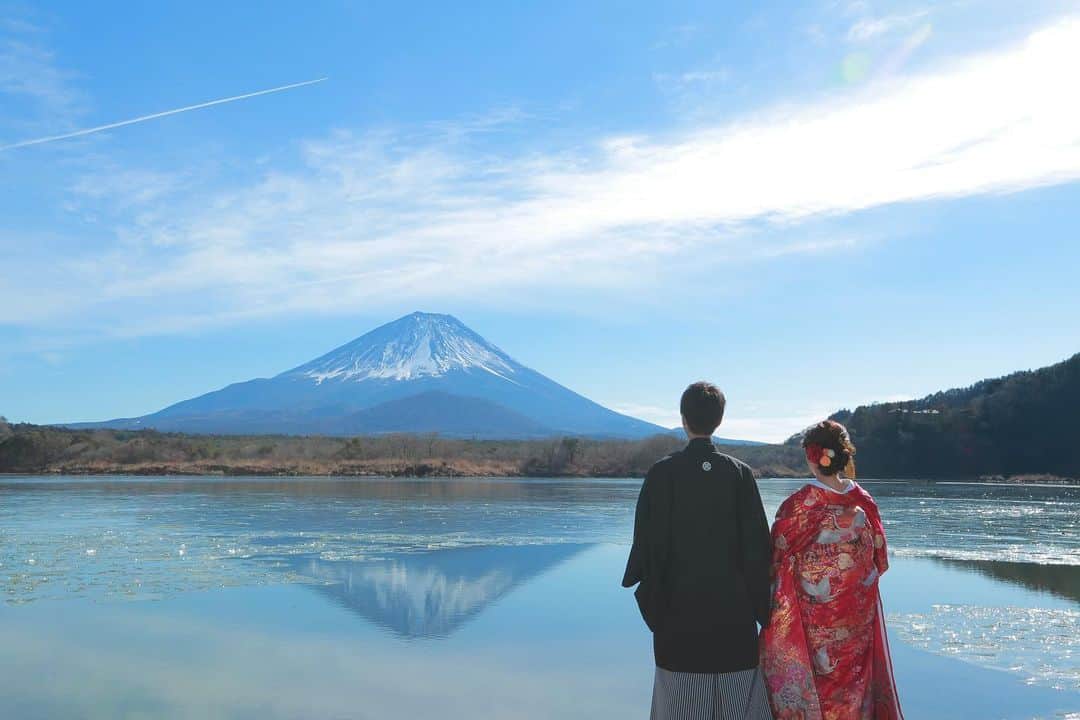 デコルテウエディングフォトグループさんのインスタグラム写真 - (デコルテウエディングフォトグループInstagram)「【保存版📝】年賀状やウェルカムボードにも使える「鏡富士」を美しく撮影する方法🗻✨ 日本ならではの壮大な景色が撮れる富士山に大注目！﻿ ﻿ 年賀状や挨拶状、﻿ 結婚式のウェルカムボードにも使える結婚写真。﻿ ﻿ 特に世界遺産で日本の象徴でもある富士は、﻿ この時期人気の撮影スポットです📸﻿ ﻿ 本日は、水面に映る富士が美しい「鏡富士」の﻿ 撮影ポイントを2つご紹介します💕﻿ ﻿ ﻿ 【１】美しい鏡富士を写す条件﻿ ﻿ やはり晴れている日ははっきりと﻿ 富士が見えるため、綺麗な写りに✨﻿ 比較的、天候が穏やかな時期を狙うと◎﻿ ﻿ ﻿ 【２】和装・洋装と異なる雰囲気に！﻿ ﻿ 日本の象徴でもある壮大な富士には、﻿ 白無垢・色打掛どちらでも美しい1枚に💕﻿ ﻿ 撮影時は動きが多いので、﻿ 洋装の場合は短めのドレスがおすすめです！﻿ 他にも、長めのベールや小物を使用して﻿ 動きのでる撮影をご提案いたします。﻿ ﻿ ﻿ 前撮りやフォトウェディングのご質問などは﻿ プロフィールのリンクからどうぞ📩﻿ @decollte_weddingphoto﻿ ご連絡、ご予約、お待ちしております！﻿ ﻿ ﻿ #令和婚 #2019秋婚 #2019年秋婚 #ウェディングフォト #結婚写真 #フォトウェディング #ウェディングニュース #ロケーション撮影 #前撮り #後撮り #花嫁準備 #プレ花嫁 #結婚準備 #花嫁 #d_weddingphoto #フォトジェニックブライドアンバサダー #富士山前撮り #鏡富士 #大人花嫁 #和装前撮り#ロケ前撮り#前撮り和装 #プレ花嫁 #富士山 #日本の絶景 #全国のプレ花嫁さんと繋がりたい #全国の花嫁さんと繋がりたい #大人ウェディング #年賀状 #ウェルカムボード」10月23日 18時56分 - decollte_weddingphoto