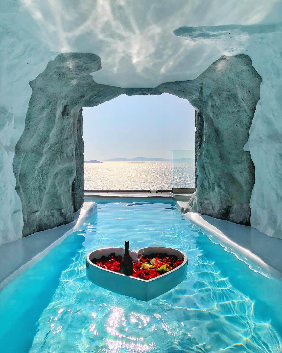 Hatice Korkmaz The Color Queenのインスタグラム：「Who wants to join me for some champagne and fruit in a floating heart 😍🥂🍉🍍🍇🍑🍓 This is amazing Cave Suit at @cavotagoomykonos 😱 #mykonos #greece #love」