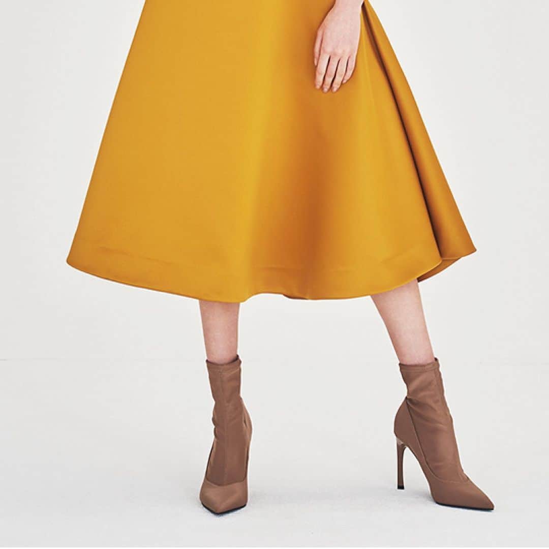 BORDERS at BALCONYのインスタグラム：「「SATIN SKIRT」は裾がベルのように揺れるイメージをデザインしました。マスタードカラーのサテンで、暗くなりがちな秋冬スタイリングをパッと明るくしてくれます。今季のパールニットやベーシックニットとのコーディネートがオススメです。」