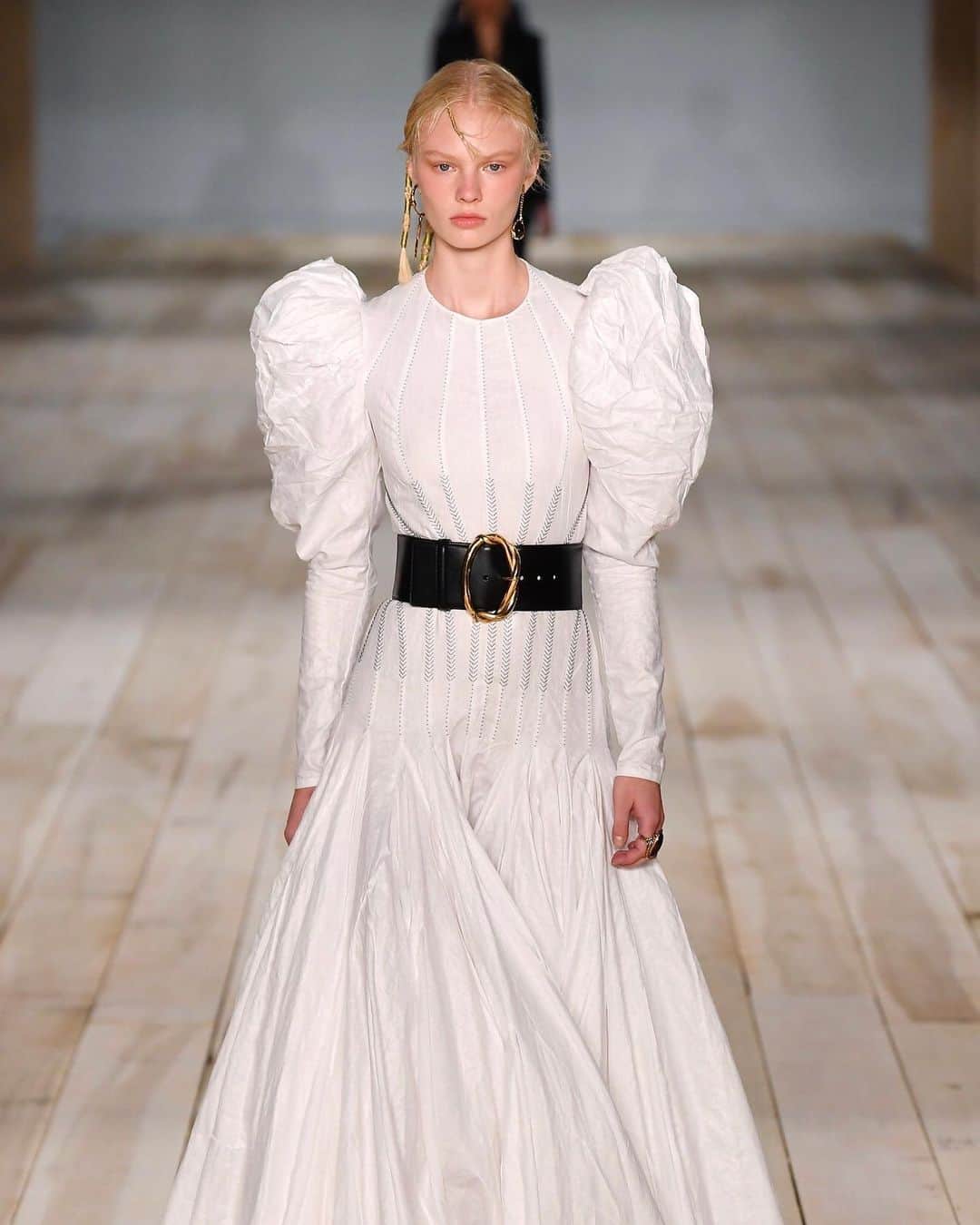 のインスタグラム：「「アレキサンダー・マックイーン（ALEXANDER McQUEEN）」の「一着一着にストーリーがある」と前書きされたリリースには42ルックの素材説明に加えて、いくつかは生産背景か記されている。オートクチュールのようにひとつひとつの服に力が注がれたコレクションだ。アイルランドに唯一残るリネンを使ったダマスク織の職人の仕事やセント・マーチン美術大学の学生との協業などが彩る。パフスリーブのドレスやタキシードジャケットなど得意とするアイテムがそろい奇抜さはないが心に響く仕上がりだ。﻿ ﻿ その他、「ステラ マッカートニー（STELLA McCARTNEY）」「サカイ（SACAI）」のコレクション・レポートはプロフィールのリンクから🔗﻿ ﻿ PHOTOS : GIOVANNI GIANNONI / WWD (c) FAIRCHILD PUBLISHING, LLC﻿ ﻿ #ALEXANDERMcQUEEN #SarahBurton #アレキサンダーマックイーン #サラバートン #2020ss #20ss #ss2020 #ss20 #PFW #PFW2019 #ParisFashionWeek #fashionweek」