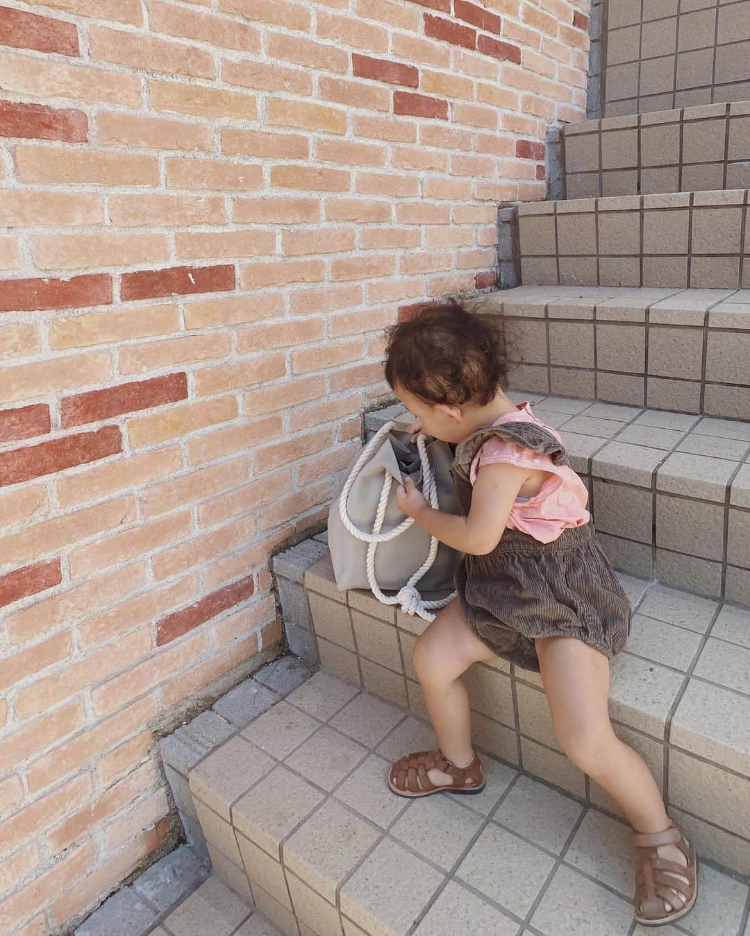 目見田早弥子のインスタグラム：「| 🌪 今日は台風一過の青空と暑さですね。 被害に遭われた地域にお住まいの方々が心配です。 お友達もみんな無事かな、心配😞... 我が家はこれといった被害はなく、家族全員無事でした。 昨日は家に引きこもりっぱなしだったので 今日は午前中から娘とお散歩してきました。 お洋服はピンクの気分だったようで ピンクのトップスを持ってきたので ブラウンのコーデュロイサロペットで合わせました🦘 娘が覗いているbagは、 @mato_by_marlmarl のもの。 実はこちら #オムツポシェット という名前で、 お尻拭きがセットできるようになっているママバッグ。 汚れにくい素材でお手入れ簡単だし容量もたくさん入るので 近くにお散歩する時はこれひとつで十分でした🌼 お尻拭き、マグ、オムツ２枚、お財布、パスケース、 ティッシュ、ハンカチ、キーケース、リップ、ハンドミラー、 サングラス、スマホなどなど...ほんとにたくさん入ります！ 紐を長くすれば肩掛けで、 両サイド同じ長さで持てばハンドバッグになるし、 バッグ本体も軽いので使いやすいです👏🏻 @marlmarl_tokyo #mato_by_marlmarl#mato_journal#マザーズバッグ#母子手帳ケース#マタニティ#新米ママ#子供のいる暮らし#ベビーグッズ#出産祝い」