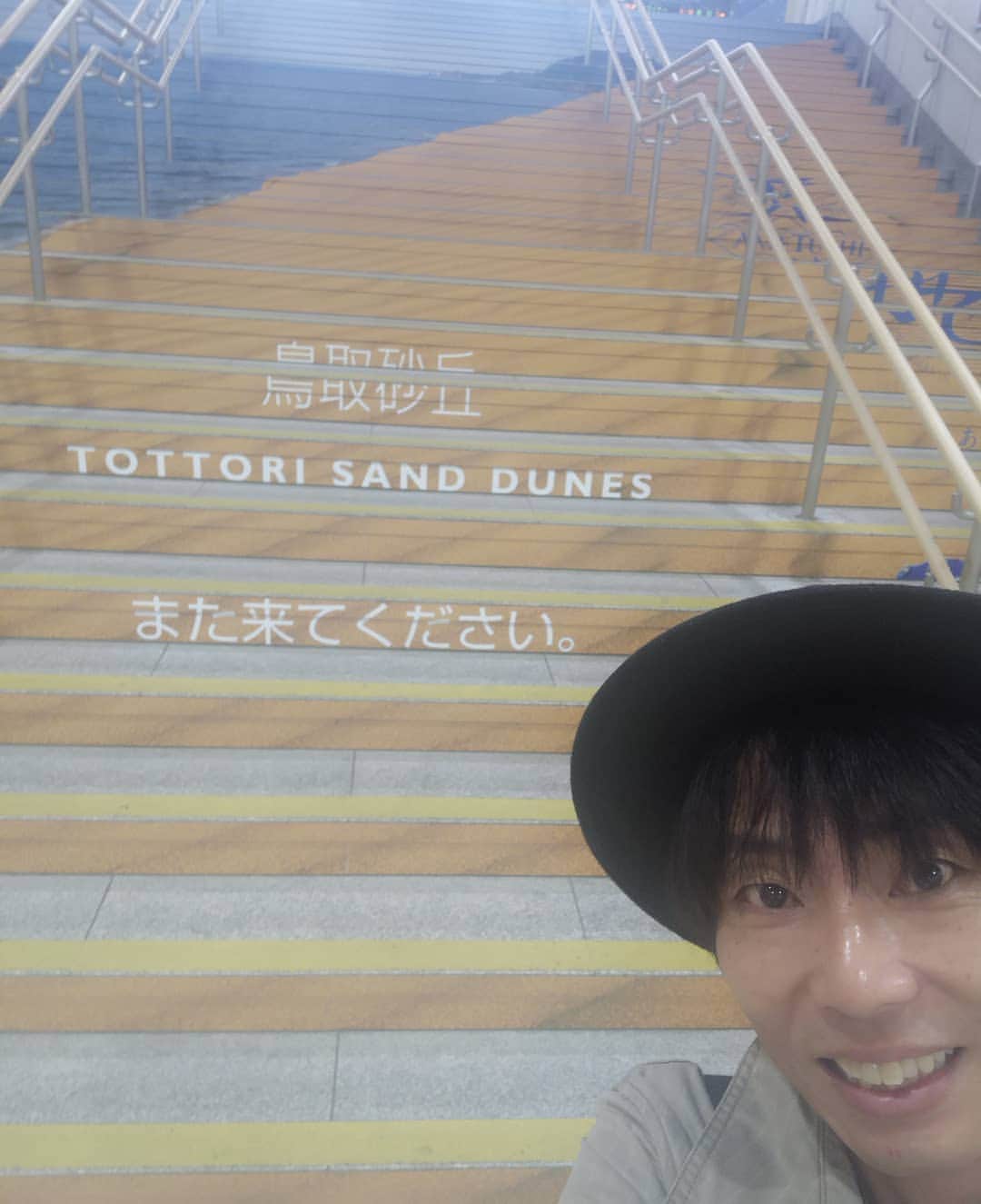 岡田達也のインスタグラム：「写真が下手でごめんなさい。 鳥取駅の階段にペイントされている、鳥取砂丘。  これから大阪に向かって『仮面山荘殺人事件』を観劇。 そしてそのまま東京へ。  畑中がシャバい芝居してたら蹴ります。  #鳥取 #鳥取駅  #仮面山荘殺人事件 #畑中智行 #岡田達也」