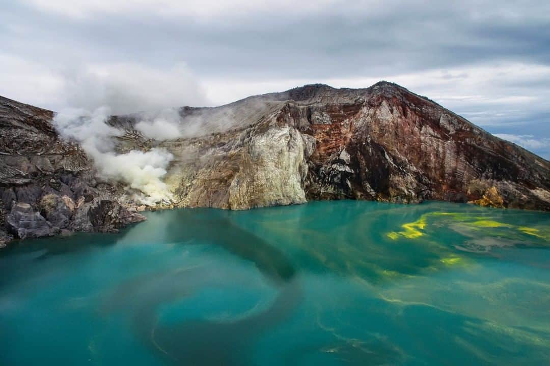 National Geographic Travelさんのインスタグラム写真 - (National Geographic TravelInstagram)「Photo by @andrea_frazzetta | Since 1968 the sulfur miners of Mount Ijen, Indonesia, have ventured into this unpredictable labyrinth of gas clouds and superheated fumaroles to extract “devil’s gold” and carry it back down the mountain. Ijen’s half-mile-wide turquoise crater lake takes on an eerie glow in the darkness.  Deceptively beautiful, it has a pH lower than that of battery acid. The largest acid lake on Earth, it is caustic enough to dissolve metal.  Follow @andrea_frazzetta to learn more about this story. #ijen #java #indonesia」10月13日 9時05分 - natgeotravel