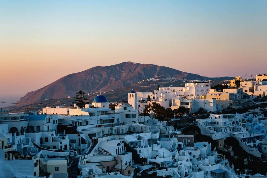 National Geographic Travelさんのインスタグラム写真 - (National Geographic TravelInstagram)「Photo by Michael George @MichaelGeorge | Santorini, Greece, will blind you. On a hot day, with the sun shining, there is nowhere to look but at the white walls, white streets, and white doorways that surround you. The occasional pops of color are an accident on a blank canvas. A flower, a cat, a hanging octopus. You wake up in a room shaped like a cave and think, Why am I taking a vacation on the edge of a dormant volcano? You wonder how the food tastes so good when the landscape looks impossible to fertilize. Garbage is brought down the stairs by donkeys. There’s another cat. You forget every color but white and blue. After breathing in the freshest air, you fly away and look down from the plane at the caldera, thinking about just how large an eruption might have been. #santorini #sunrise #greece #caldera #volcano」10月14日 9時05分 - natgeotravel