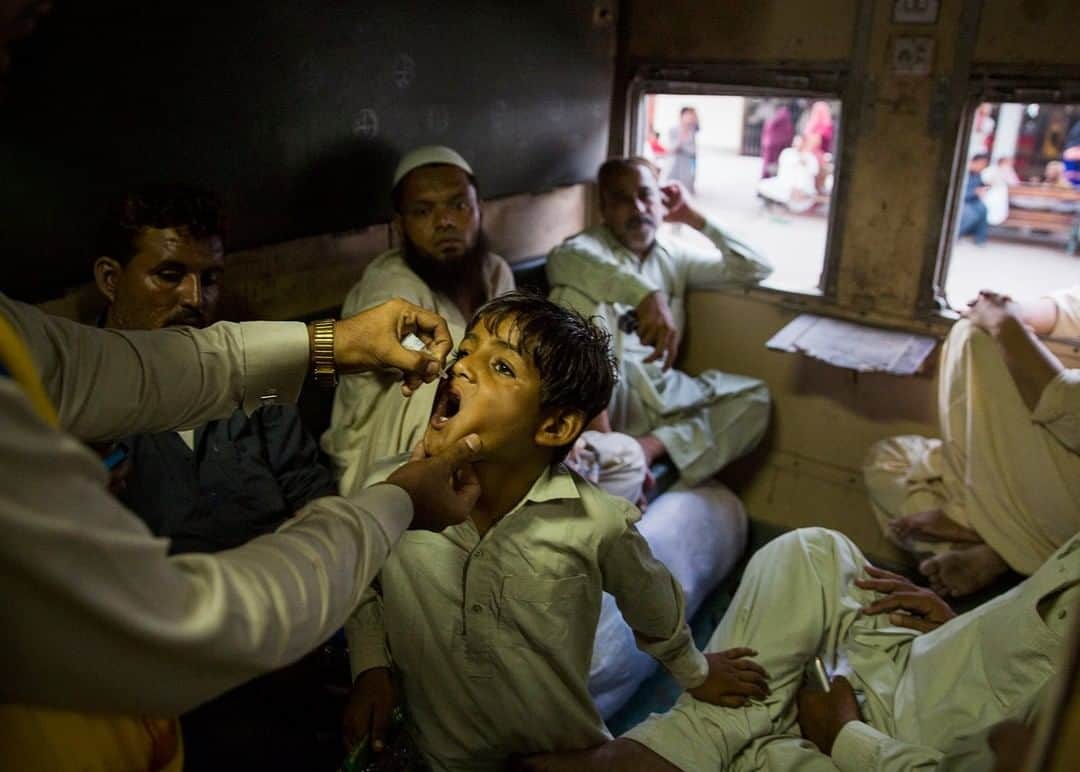 のインスタグラム：「Photo by William Daniels @williamodaniels | Seeking out the unvaccinated in Karachi, Pakistan, a health worker finds a boy who lacks the mark on his finger that would indicate he’s previously been inoculated against polio. The oral vaccine has to be dispensed quickly, before the train on which he's riding pulls out. Follow me on @williamodaniels for more human stories around the world.」