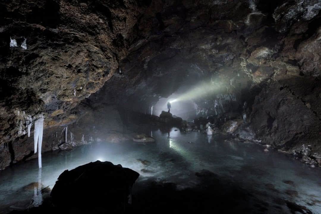 National Geographic Travelさんのインスタグラム写真 - (National Geographic TravelInstagram)「Photo by Robbie Shone @shonephoto | Having left the thick fog swirling around Mount Etna, an explorer descends into the misty subsurface. Grotta del Gelo is a lava tube that formed following the cooling of a lava flow during an eruption that began in July 1614—and lasted for over 10 years. Her headlamp cuts through the cloud, revealing a reflective, crystal clear lake on top of a large mass of ice. Grotta del Gelo is unusual; finding lava tubes with ice inside is a rarity. Huge thanks for the support from the Sicilian Speleogical Fédération and Etna National Park for making this trip happen.」10月15日 9時04分 - natgeotravel