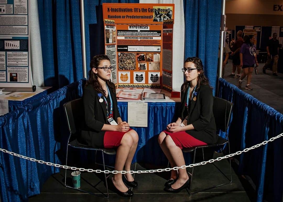 のインスタグラム：「Photo by Dina Litovsky @dina_litovsky | Twin sisters Gina and Lisa Sobinovsky, from West Virginia, present their research about the connection of fur color in cats to cancer at the 2019 International Science and Engineering Fair, a prestigious event attracting students from around the world. Though young women have been a minority in STEM fields in the past, this year’s fair was evenly split by gender—a jump from just 35 percent female in 1960.  This story on girls in science was shot for National Geographic’s November issue. For more images follow me @dina_litovsky.」