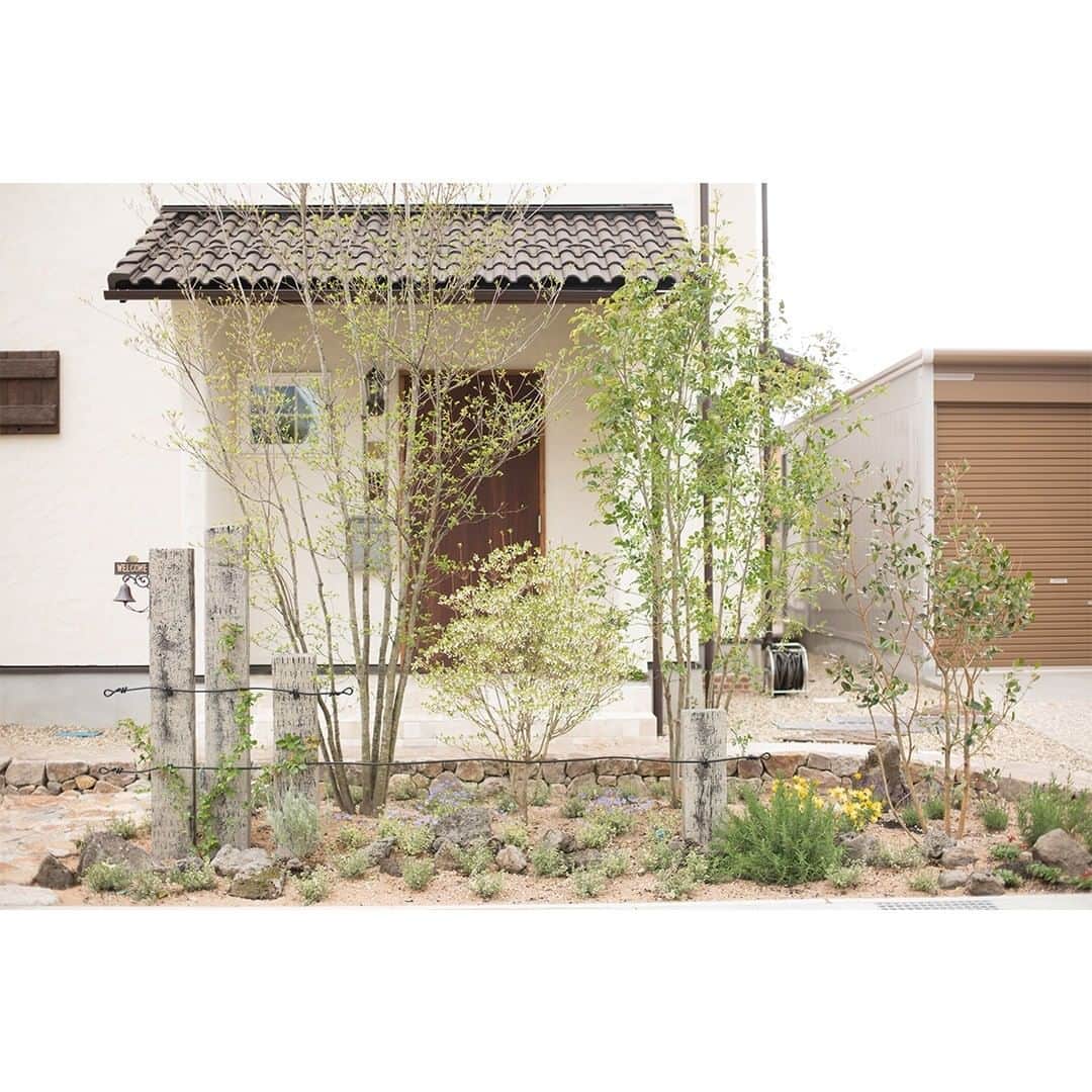 homelife 夢を叶える暮らし方のインスタグラム：「【シンボルツリー🌳】 . . シンプルな樹々と可愛らしい花が素敵な玄関を演出🌳 様々な木がバランスよく配置されていますね . . こちらのお家はアーキホームライフのお施主様邸の施工写真です。 その他の施工写真は、 @homelife_gallery のURLからご覧いただけます。 . 家づくりの資料請求はコチラから @homelife_shiryou . . #シンボルツリー #外構デザイン #自然素材 #玄関 #シンプル #こだわり #京都で家を建てる #大阪で家を建てる #兵庫で家を建てる #マイホーム計画 #ローコスト住宅 #マイホーム #夢のマイホーム #間取り #シンプルな暮らし #暮らしを楽しむ #注文住宅 #自由設計 #デザイン住宅 #myhome #family #house #home #homelife_京都 #homelife_大阪 #homelife_兵庫 #ホームライフ #ホームライフ100 #アーキホームライフ」