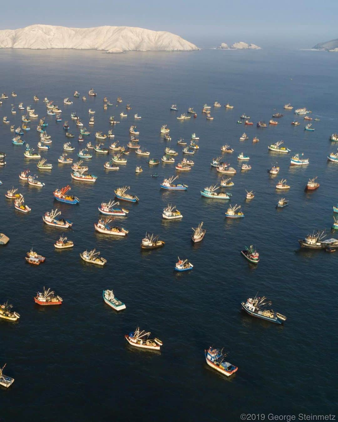 ナショナルジオグラフィックさんのインスタグラム写真 - (ナショナルジオグラフィックInstagram)「Photo by George Steinmetz @geosteinmetz | Purse seiners wait for the opening of Chimbote Harbor, Peru. The Peruvian anchoveta is the world’s largest fishery by tonnage; the fish is primarily harvested for fishmeal and oil, critical components of feed for aquaculture, pig, and chicken farms throughout the world. To view more of our world from above, follow @geosteinmetz.」10月18日 21時40分 - natgeo